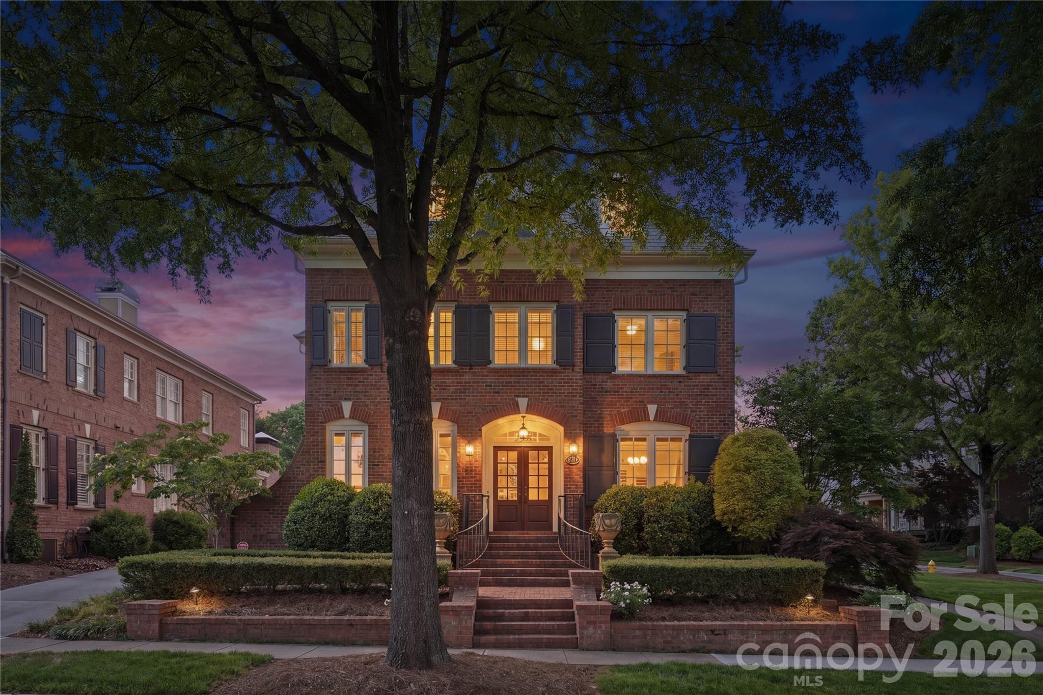 Simply stunning Simonini Builders full-brick residence in the gated Heydon Hall community, ideally positioned in the heart of SouthPark. Thoughtfully designed with refined finishes, the home offers 10-foot ceilings on the main level and hardwood floors throughout. The kitchen is both functional and beautifully appointed, featuring expansive quartzite countertops, floor-to-ceiling cabinetry, a built-in china cabinet, and a walk-in pantry with custom shelving. Premium appliances include a Thermador double oven, a Thermador gas cooktop with griddle with a Themador range hood above, and a Thermador microwave, along with a GE Monogram dishwasher. A recessed pop-up outlet in the oversized island and powered shades in the breakfast area add convenience. The kitchen flows seamlessly into the main living space, where a lighted tray ceiling, marble-surround fireplace, and custom built-ins create a warm, polished setting. Formal dining connects via a butler’s pantry with a GE Monogram wine refrigerator for easy entertaining. A dedicated office on the main level includes a full bath and solid pocket doors, offering flexibility as a private guest suite. The laundry room is also on the main level and includes a utility sink and a built-in drop zone with four individual storage areas, complete with drawers, hooks, and cubbies. Upstairs, the primary suite features a lighted tray ceiling, detailed moldings, and a spacious layout. The ensuite bath is finished with marble flooring, a soaking tub, dual vanities with marble countertops, and a separate tiled shower. The custom walk-in closet is designed for organization. Three additional bedrooms complete the second level—two connected by a Jack and Jill bath, and one with its own ensuite. The third level expands the living space with a full bath featuring a steam shower, a large recreation area suitable for media or game use, and a separate fitness space. A well-appointed wet bar enhances the level, complete with a GE Monogram beverage refrigerator, GE Monogram ice maker, and granite countertops, creating an ideal setup for entertaining. Outdoor living is equally considered, with double French doors opening to a covered patio with beadboard ceiling, paver flooring, a ceiling fan, and a privacy wall designed to accommodate a mounted TV. The outdoor kitchen includes a built-in Summit refrigerator and a dedicated grill area with a gas line, creating a functional setup for everyday use or entertaining. The flat backyard is enclosed by a combination of brick and metal fencing, offering both privacy and openness. A stepping-stone path leads to a secondary paver patio centered around a wood-burning fireplace with a gas starter. A detached two-car garage provides additional storage, epoxy flooring, and built-in cabinetry.