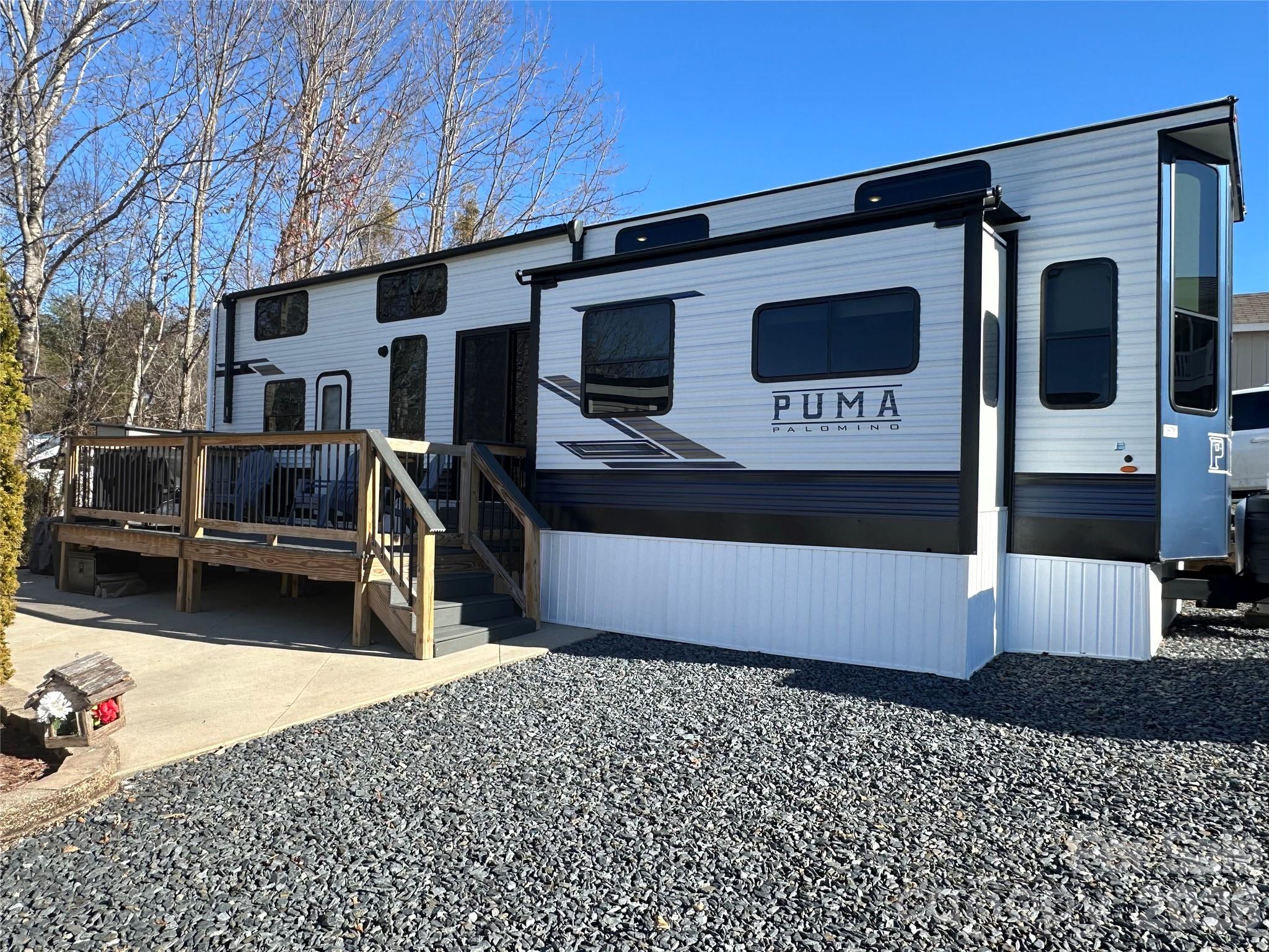 Almost-new 2024 destination camper at Badin Lake—enjoy a lake view right from your sofa! This beautifully appointed camper is loaded with modern features, including a kitchen center island with sink, full-size side-by-side refrigerator, electronic blinds, electric fireplace, instant hot water, washer/dryer, and a spacious bedroom with a king-size bed.  Dual sleeping lofts provide ample space for guests, and the step-in shower adds everyday comfort. Outdoor living is just as impressive with the push-button retractable awning over a covered deck, low-maintenance composite decking, and a concrete patio complete with firepit, picnic table, and storage locker. The sellers are even leaving the grill—just bring your clothes and start enjoying lake life! Located inside the gated waterfront community of Badin Shores Resort, residents enjoy amenities such as a swimming pool (seasonal), putt-putt golf, fishing pier, man-made sandy beach, designated lake swim area, waterfront boardwalk and more.
