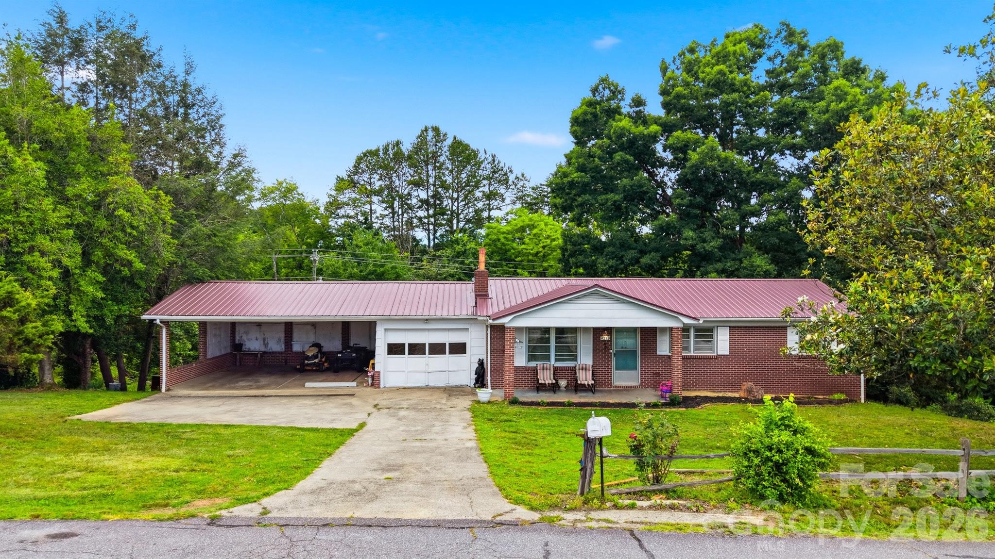 Charming brick ranch situated on two parcels, approximately 1.79 acres in Hudson offering the perfect blend of privacy and convenience. This 3-bedroom, 1-bath home features hardwood floors, a spacious living room with fireplace insert. Spacious kitchen with plenty of storage looks over the back yard and has a separate dining area. The full basement provides abundant storage, workshop space, or future expansion possibilities. Outside, enjoy the covered front porch, attached carport, mature trees, and a seasonal stream that adds to the property’s peaceful setting. With two parcels included, there is ample room for gardening, outdoor recreation, or simply enjoying the surrounding landscape. Two car carport with an additional single car garage. Carport features a service pit, convenient under-vehicle access for maintenance. Huge yard with mature landscaping, fruit trees and grape vines. Conveniently located just minutes from schools, shopping, dining, and major highways while maintaining a quiet, country feel. A wonderful opportunity for first time buyers seeking acreage, character, and room to make it their own.