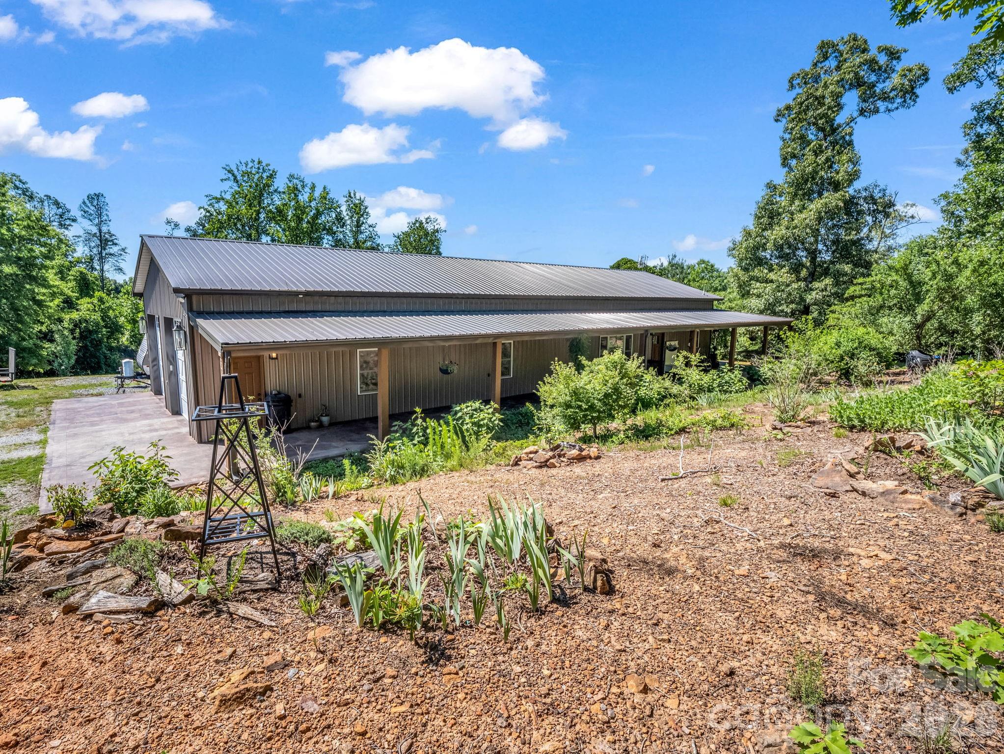 Discover the perfect blend of country living, self-sufficiency, and modern comfort on this beautiful 4.35-acre homestead in Forest City. This charming 2-bedroom, 1.5-bath home offers a peaceful rural setting with thoughtfully designed spaces both inside and out.

Step inside to find a warm and inviting floor plan with comfortable living areas that make everyday living and entertaining a pleasure. One of the home’s standout features is the oversized attached garage, which is fully heated and cooled by its own dedicated HVAC system, creating exceptional year-round functionality. Within this space is a versatile office/recreation area, perfect for working from home, pursuing hobbies, exercising, or creating additional living space to fit your needs. Above the garage, a spacious bonus room provides even more flexibility and could serve as a guest retreat, media room, craft room, home gym, playroom, or additional storage area. And when the power goes out? This home keeps going with the included whole-house propane generator.

Outside, the property is a turnkey homesteader’s dream. Multiple fenced areas are already in place for livestock, and the current setup supports goats and chickens, making it easy to continue a sustainable lifestyle from day one. The owners have carefully maintained the property using organic fertilizers and pest control practices, creating a healthy and productive environment for gardening and farming.

Grow your own food with six raised garden beds filled with rich organic soil, currently producing potatoes, asparagus, and herbs. Enjoy harvesting from established fruit trees including plum, pear, peach, and fig. The landscape is further enhanced by mature lavender, sage, rosemary, thyme, and beautiful ornamental plantings that provide year-round color and charm.

A storage building offers additional room for tools, equipment, feed, or workshop space. With over four acres of usable land, established homesteading infrastructure, and flexible living spaces rarely found at this price point, this property offers a unique opportunity to embrace a slower pace of life without sacrificing convenience.

Whether you’re searching for a mini-farm, hobby farm, homestead, country retreat, or simply a place with room to grow, this exceptional property delivers the lifestyle you’ve been dreaming of. Come experience the beauty, functionality, and possibilities that await at 372 Horn Bottom Road.