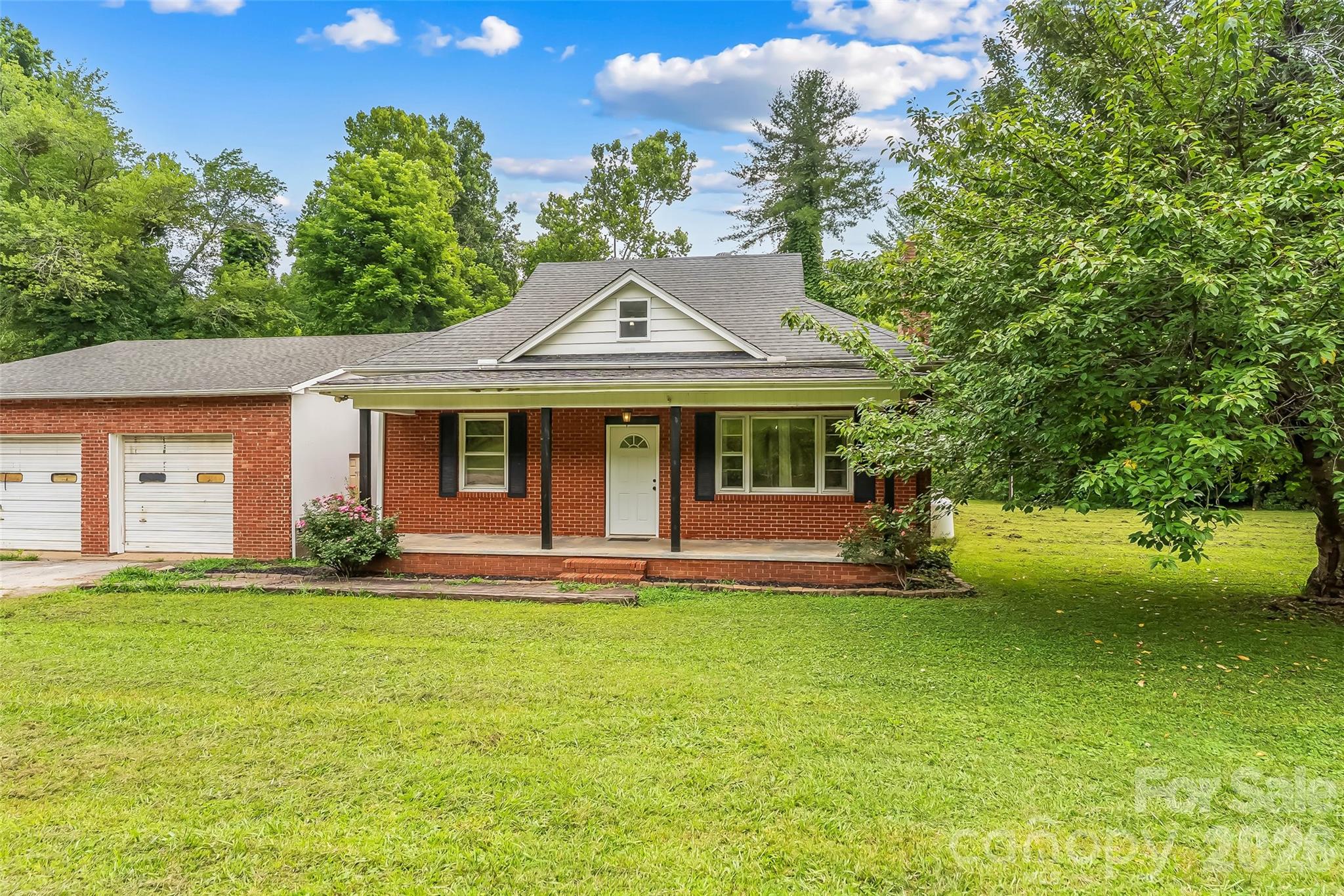 Opportunity, flexibility, and charm in one property! This 1920's brick Craftsman-style home offers a move-in ready option with room to bring your own ideas and vision. A covered front porch welcomes you inside to warm knotty pine details throughout. 

The home offers 3 bedrooms, 1 full bathroom, mini-splits and a cozy wood-burning stove in the living room fireplace. Up the stairs, you will find bonus space previously used as a 4th bedroom. Complete with its own mini-split, this room offers tons of versatility. 

Outside, fencing surrounds the property for added privacy and peace of mind, while multiple gates offer convenience. The level yard provides ample usable space for gardening, enjoying the outdoors, or future possibilities. A trickling creek runs along the back of the property.

Two separate workshop spaces make this property especially unique: a two bay brick detached garage plus a large two bay building previously used as an auto shop. Whether you need space for equipment, vehicles, or hobbies, these workshop spaces support a wide range of creative uses.

Just minutes to your everyday needs in Marion, you'll find this property very well-situated. ~15-20 minutes to: trailheads and numerous trails including the Fonta Flora State Trail, Lake James and the town of Old Fort. ~30 minutes to Black Mountain and ~40-45 minutes to Asheville. This property has it all, potential, comfort and close to so many of the amazing things WNC has to offer!