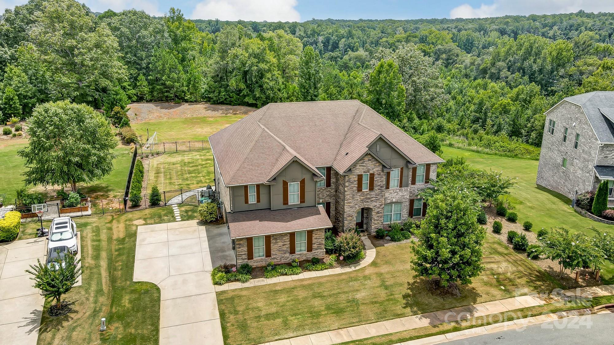 Welcome to 4202 Thames Circle, a stunning 5000+sqft estate backed by green space with direct access to the Catawba River and a community pavilion with a kayak launch. This 5-bed, 3.5 bath home boasts a custom-built resort-style pool with hot tub and full outdoor kitchen. The gourmet kitchen features a Calacatta Gold Extra marble island, quartz counters, marble tile backsplash, white shaker cabinets, a gas cooktop, double ovens, and a walk-in pantry. The floor plan includes a large private study and flex/bonus space on the main floor. Upstairs, you can find a spacious primary bedroom with a custom walk-in closet, 4 secondary rooms (2 oversized), and a large bonus loft area. Hardwood floors adorn the main level, stairs, and primary bedroom. The premium fenced lot offers serene views of the Catawba River. Additional features include an oversized 3-car garage, whole-house filtration system, freshly painted exterior, and Energy Star certification with spray foam insulation. MOVE-IN READY!