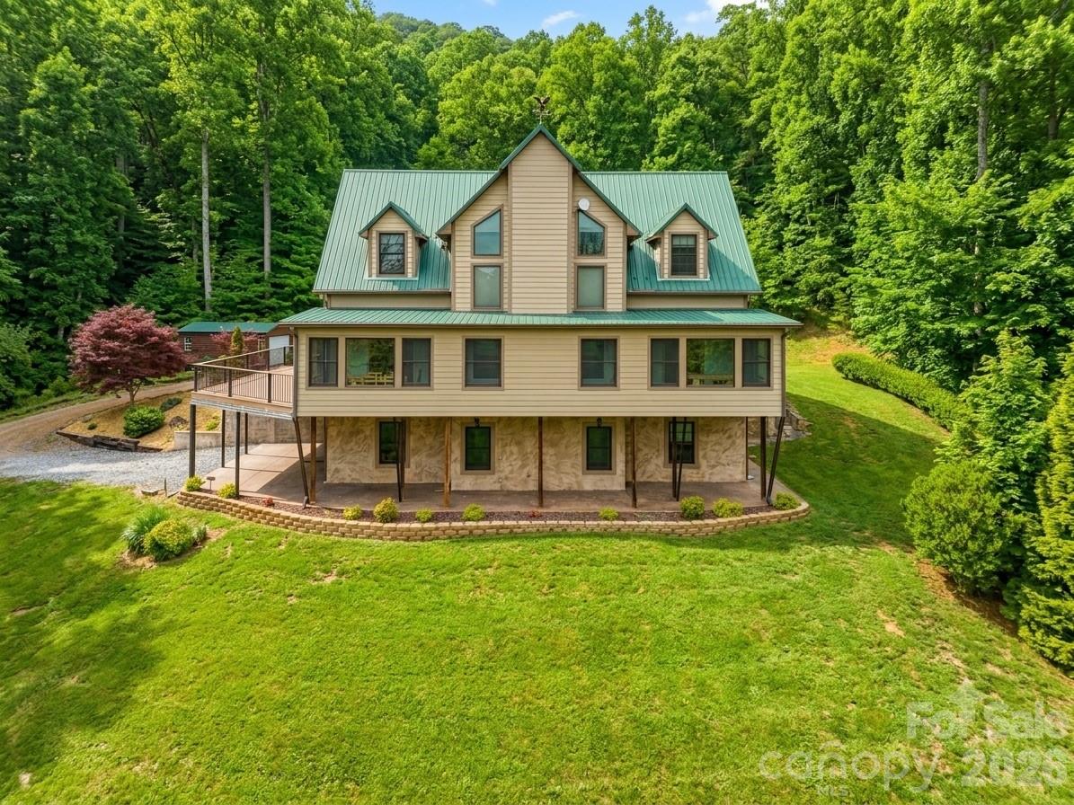 Imagine waking up to long range mountain views, fresh air, and total privacy on 3.66 unrestricted acres. This custom 4 bedroom mountain retreat in Sylva delivers 4,605 square feet of modern mountain design with luxury rustic finishes and flexible living space built for comfort and opportunity. Large windows fill the home with natural light while two fireplaces create a warm, inviting atmosphere. The main living area opens to a massive Trex deck made for entertaining, with a covered patio below that extends outdoor living year round. The primary bath features a spa style steam shower and jetted soaking tub combo with glass enclosure, body jets, rainfall showerhead, and built in seating for a true at home retreat. A fully finished basement apartment offers ideal space for guests, multigenerational living, or short term rental potential. With year round access, ample parking, and close proximity to Sylva, Dillsboro, Western Carolina University, breweries, dining, the Tuckasegee River, and hiking trails, this property blends peaceful mountain living with everyday convenience. Access to the property is currently via a mountain road that may not suit every preference. However, the property offers potential for an additional entrance or driveway from the upper portion of the land, providing flexibility for future access options.