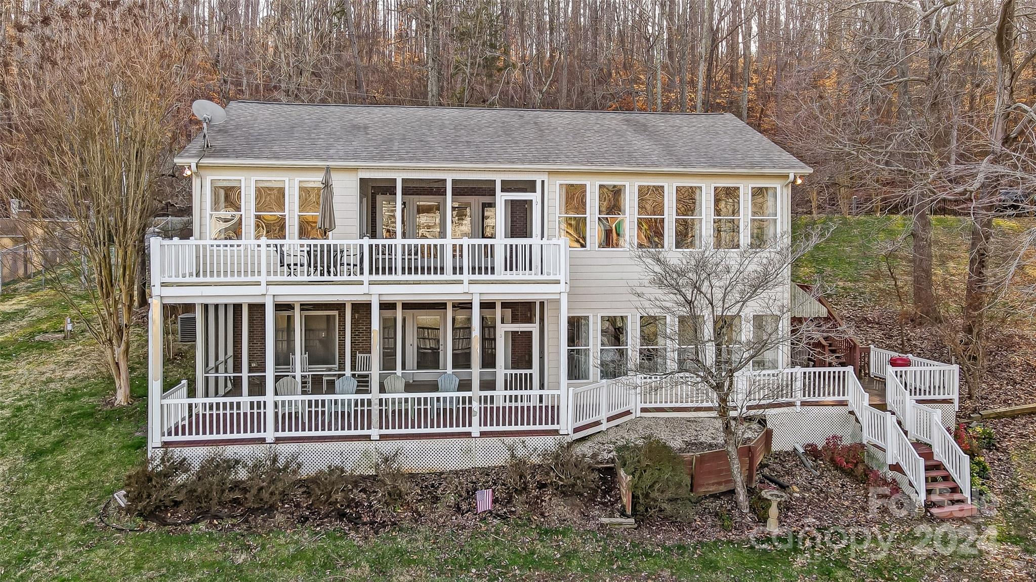 This waterfront gem is sure to "WOW" you with amazing views of Lake Wylie! The 2 screened porches, multiple decks, spacious yard, & floating dock are perfect spots for outdoor entertaining or to take in the views. Tax record shows age of home as 1945, however, it was rebuilt in 1996.  This home has it all – beautiful floors, crown molding, open floor plan, & tons of windows. You’ll love the kitchen featuring SS appliances, large island, & granite counters opening to the great room, sitting room, & dining area w/ fireplace. Main level primary suite provides walk-in closet, sitting area, updated bath, & access to screened porch. Lower level is perfect for 2nd living quarters featuring sunroom, large rec room w/ fireplace, 2nd kitchen, 2nd laundry, storage, & bedroom w/ full bath. Fenced yard w/ gated entry.  Located on a wide cove opening to the main channel, the best of both worlds. Get away from it all, yet live close to River District, shopping, dining, Uptown Charlotte, & airport.