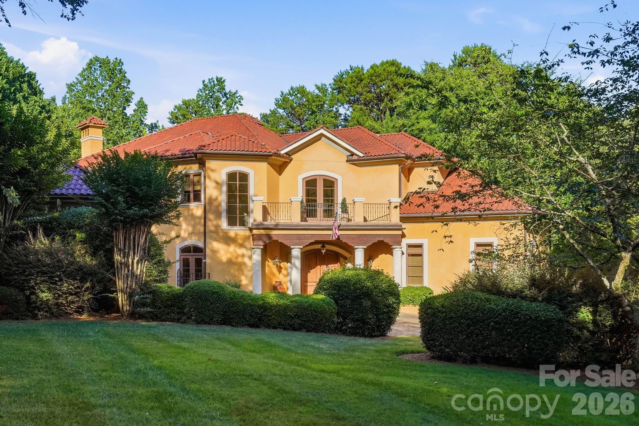 Gracefully positioned along a wide, open stretch of Lake Norman within the prestigious Trump National Golf Course, The Point, on approximately one acre of land with over 200 feet of water frontage, this European inspired estate blends timeless architecture with elevated lakefront living. Warm stucco exteriors, French doors throughout, arch windows and rich wood detailing create a striking first impression, while inside, twelve-foot ceilings, exposed beams, travertine fireplaces and hand crafted cabinetry reflect old world craftsmanship rarely found today. Expansive windows and French doors frame sweeping water views and seamlessly connect the interior to lower and upper outdoor terraces. The primary suite is thoughtfully located on the main level, offering a private retreat complete with a jacuzzi tub, dual vanities, large walk-in shower, expansive walk-in closets and separate sitting area. Upstairs, generously sized secondary bedrooms, each with their own bath and shower, are complemented by a dedicated office, craft room and spacious game room with kitchenette and pool table, providing exceptional flexibility for modern living and entertainment. The walk out lower level contains a fully equipped exercise room, workshop, abundant storage and an additional two-car garage for the auto minded enthusiast, complimented with a car lift. Outside, a private dock with boat lift extends your living experience onto the water with a dedicated dining area allowing long-range views of the lake. The private cove is ideal for boating, paddle boarding, kayaking and sunset cruises. For the less adventurous, the home has an in ground 8x8 heated spa supported by its own cabana with half-bath and outdoor shower. A rare opportunity to own a distinctive waterfront residence in one of Lake Norman’s most sought-after golf and waterfront communities.