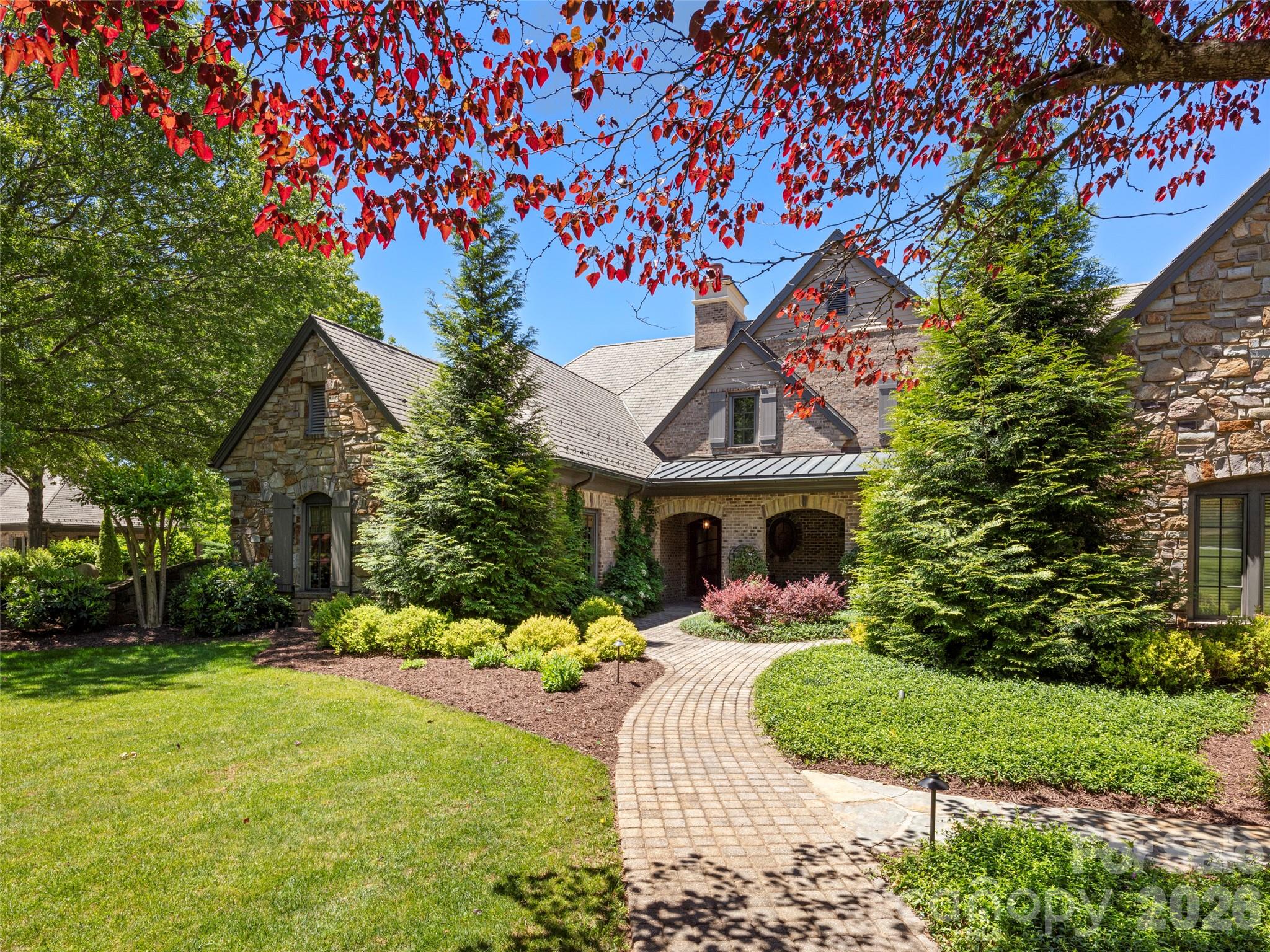 Secure the most coveted vantage point in the Cliffs at Walnut Cove as the Biltmore Championship Asheville brings the PGA TOUR back to our region in September 2026. This residence offers an unrivaled private gallery, featuring large-scale picture windows which allow the premier view of the final hole’s high-stakes drama—a luxury no other currently listed property in Walnut Cove can claim. Experience European-influenced luxury in this sophisticated duplex, where the effortless lifestyle of a townhome meets the expansive proportions of a grand estate. High ceilings and high-end Pella windows bathe the home in natural light, framing breathtaking southwesterly vistas of the Jack Nicklaus Signature course. The open-concept kitchen is a study in functional art, anchored by a premium Viking appliance suite, a dedicated wine cooler and a social center island. The dining area features a large bay window and sitting area in front of a fireplace. The main-level primary suite features a spa-like bath and custom walk-in closet. For those working from home, an inviting study/additional bedroom suite offers a quiet retreat and great views of the 9th hole. The main level is rounded out with a stately living room with coffered ceilings and fireplace. The lower level expands the living area significantly with a generous family room and three additional guest suites, each with private en-suite baths, ensuring ultimate privacy and comfort for family and friends. The transition between indoors and out is seamless, designed for the discerning entertainer. A large, covered porch with Phantom screening offers a sophisticated space to enjoy the mountain breeze from the main level, while the expansive lower patio provides a perfect vantage point for the surrounding peaks and the golf course. Membership unlocks a world-class lifestyle, including the 18,000-square-foot wellness center, with indoor and outdoor pools and tennis courts.  Enjoy fine dining in the Tavern, wine room and pub with a beer garden.  The Golf House features well-appointed locker rooms, award-winning pro-shop and Turn House Café. Bordering the Pisgah National Forest and located minutes from the Blue Ridge Parkway and Asheville, this property offers a rare combination of high-altitude privacy and front-row access to professional golf's elite. Cliffs Membership is available for purchase.