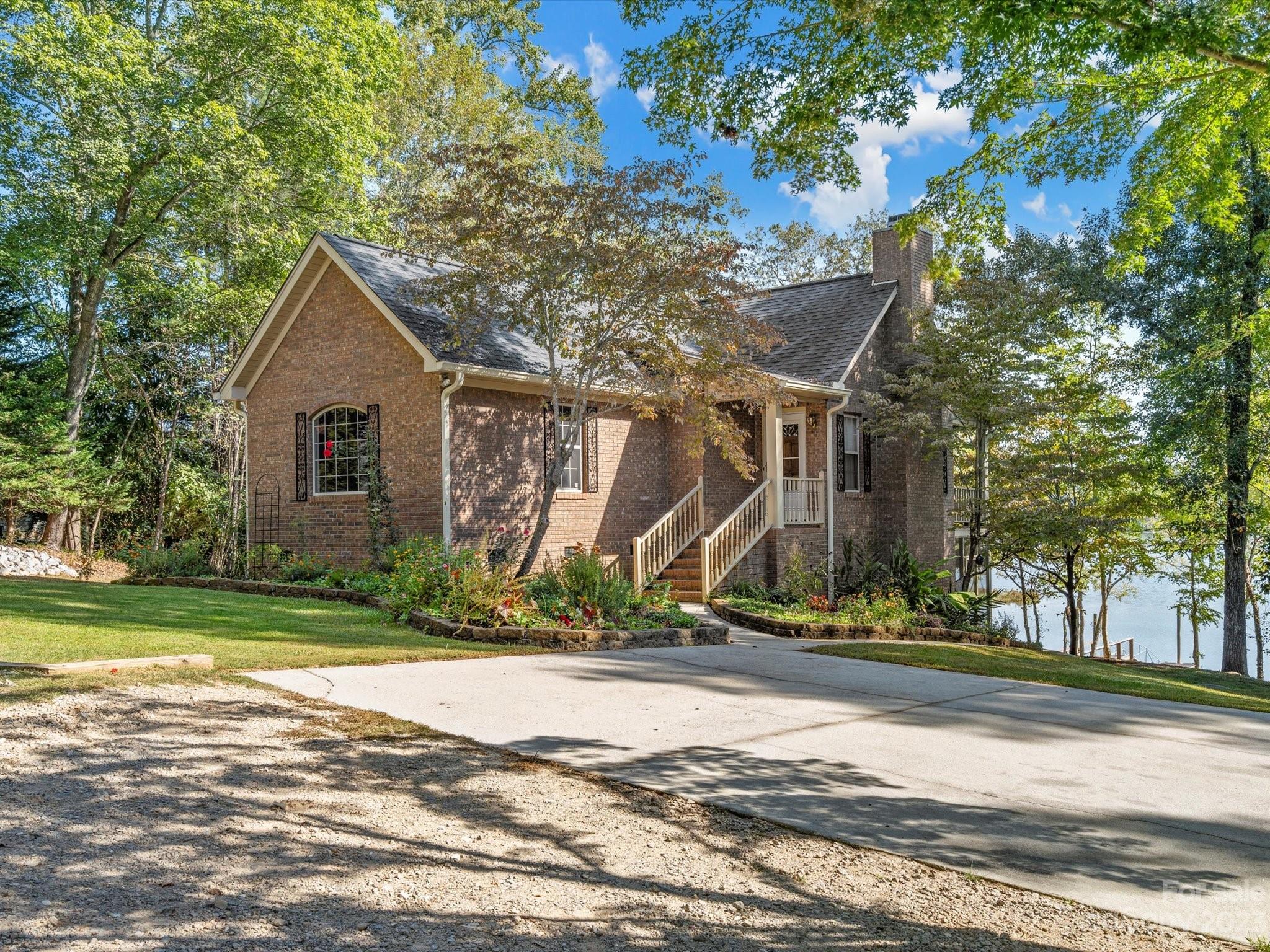 Charming 3BR/2BA, full-brick, lakefront home tucked away on approx. 2 acres on Lake Wateree. Positioned at water's edge, this private property offers a stunning wide lake view, a 98' dock (built 2021) to enjoy the gentle breeze. Approximately 6' of water at floating dock, so plenty of room for multiple boats. From the home, enjoy the views and fresh air from the main level deck or from the downstairs screened porch. Primary BR on main; two secondary BRs and bath on basement level. Sellers made numerous updates: installed gutters with screens, expanded driveway for more parking (10+ cars), added fresh gravel to driveway, added retaining wall in front of property (with felt paper under rocks), cut underbrush along sides of driveway to streamline property aesthetics and added large flower bed. Roof was new in 2019. Wood-burning fireplace. Ask about available water toys! New carpet installed 10/13/23 after the photos were taken in two secondary bedrooms and stairs!