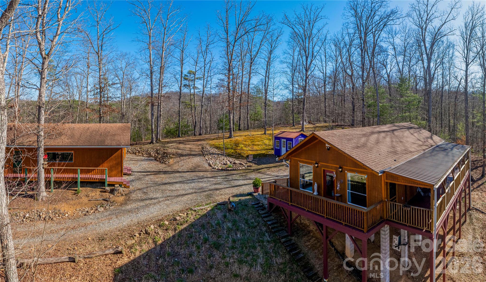 At the top of the mountain, on a private ridgeline, this rare Blue Ridge retreat on 5 acres offers long-range mountain views and a separate 981 SF studio/workshop building with electric and water already in place. Surrounded by breathtaking 360-degree mountain views with expanded seasonal visibility, this mountaintop sanctuary offers an immersive sense of peace, clarity, and inspiration that’s increasingly hard to find.

Immersed in privacy, this is more than a home, it’s a retreat, a creative escape, a place where time slows and ideas take shape.

Inside, expansive picture windows fill the space with natural light while framing the surrounding mountains, seamlessly connecting indoors with the landscape beyond. Inviting decks offer the perfect setting for quiet mornings, evening stargazing, and uninterrupted stillness.

Turnkey if desired, most furnishings and TV can be included, offering an effortless transition into mountain living. With no restrictions, the property is well-suited for a retreat setting, musician or artist studio, homestead, or private getaway.

A new insulated outbuilding provides secure, airtight storage for equipment and seasonal items. An existing septic permit allows for expansion to an additional bedroom, while additional buildable areas offer further potential for thoughtful growth. High-speed fiber optic internet brings modern convenience to this private mountain setting. 

Located just 10 minutes from downtown Hot Springs, you’ll have access to natural mineral springs, the Appalachian Trail, hiking, waterfalls, swimming holes, rafting, and outdoor adventure. Asheville, NC and Knoxville, TN are both within reach, offering the ideal blend of peaceful mountain living and accessibility. 

A rare offering for those seeking privacy, land, long-range views, and future potential. By appointment only, no drive-bys, please.