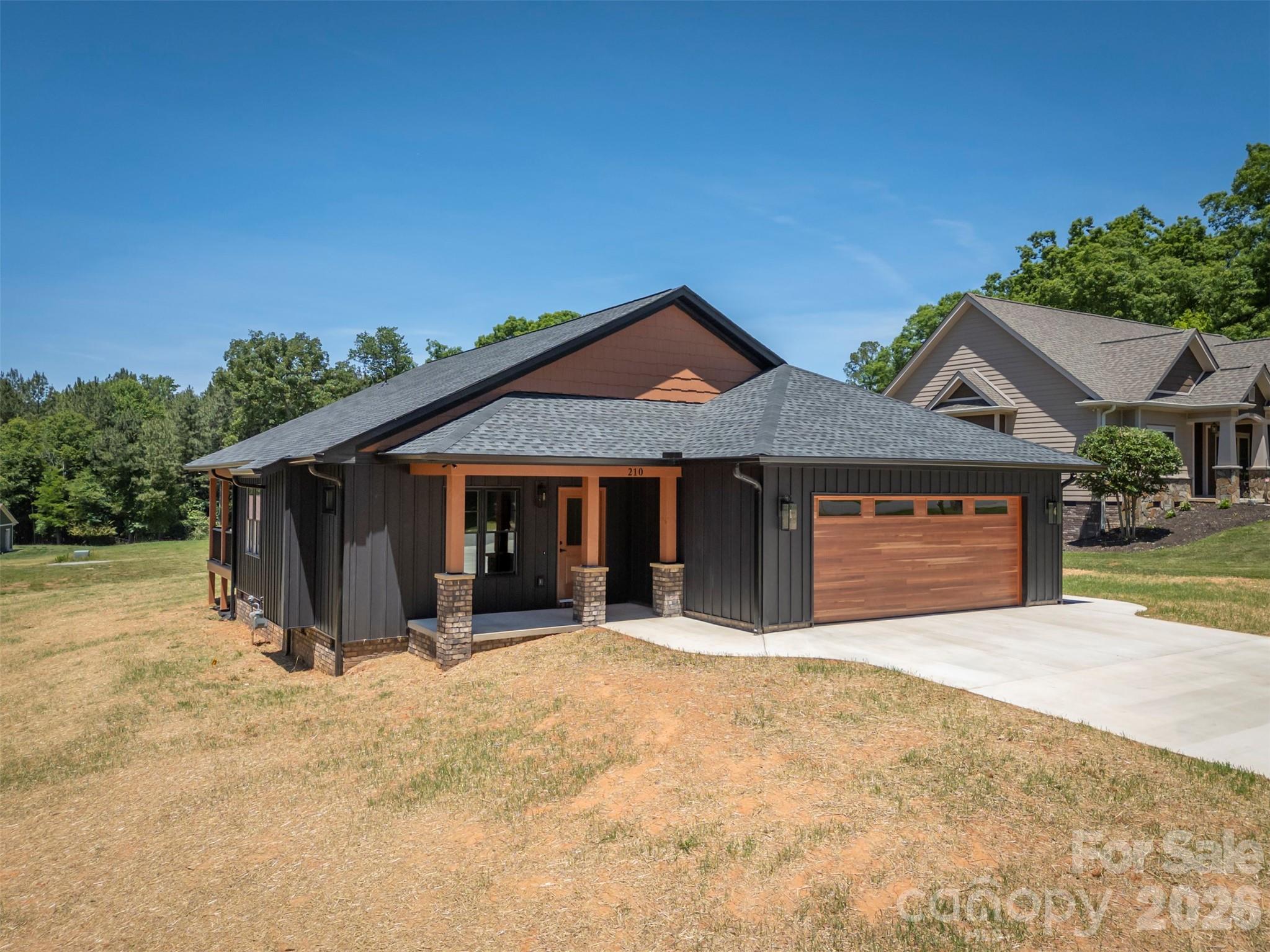 Welcome to this stunning new construction home offering the perfect blend of modern style, comfort, and convenience! From the moment you arrive, you will be impressed by the striking exterior featuring rich dark siding, warm wood accents, beautiful brick, and an inviting covered front porch. Step inside to discover a spacious open-concept layout with a beautiful great room anchored by a cozy gas fireplace, creating the perfect space for relaxing or entertaining. The large kitchen is truly a showstopper, with custom cabinetry, an oversized island, a pantry, stylish finishes, and quality appliances, including a gas stove that will delight any home chef. The primary suite is designed to impress with a spacious bedroom retreat, massive walk-in closet, and an incredible spa-like bathroom featuring a huge walk-in shower. Two additional bedrooms and an additional full bathroom provide plenty of space for family, guests, or a home office setup. You will also appreciate the large laundry room offering both convenience and extra storage space. Enjoy outdoor living year-round with both a welcoming covered front porch and a spacious covered back porch, perfect for relaxing mornings or entertaining guests. Additional highlights include a two-car garage and thoughtfully designed modern finishes throughout the home. Located just minutes from downtown Forest City, you will love having easy access to local pubs, restaurants, shopping, and community events. With its convenient location, you are just a short drive to Charlotte, Spartanburg, and Asheville, making commuting or weekend getaways a breeze. This property offers small-town charm with big-city accessibility—don’t miss your opportunity to make it yours!