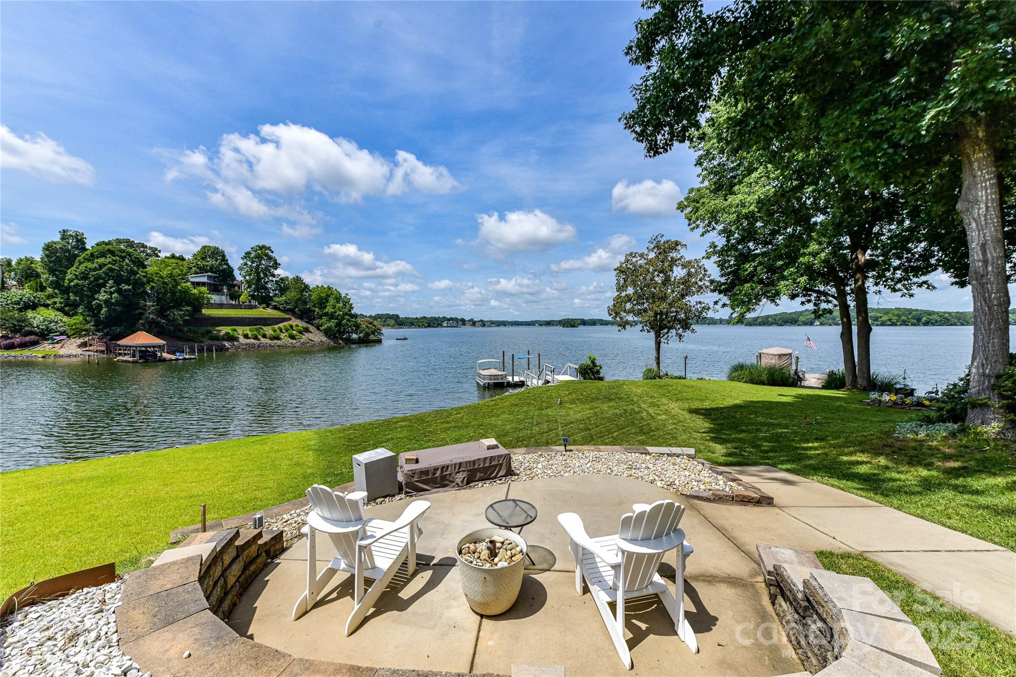 Spectacular Sunsets and Panoramic views of Lake Wylie's main channel in Tega Cay. Meticulously remodeled from top to bottom including new additions. Additions include a huge primary suite w/ vaulted ceilings, 2 walk-in closets, covered deck, ensuite bath, dual sinks, freestanding tub, separate shower and marble floors. Main level features 2 bedrooms, 2nd Primary suite with ensuite bath, full bath, 1/2 bath, sunroom, open living room w/ soaring ceiling accented with wooden beams, gas fireplace, laundry room and chef's kitchen. Natural hardwood floors and Plantation shutters throughout. Step outside onto the expansive composite deck and enjoy the mesmerizing waterfront views. Newly built floating composite dock, firepit area and steps down to the water.  Irrigation in back yard is pumped from the lake.  Large attached  2 car garage with 3rd bay for golf cart or work out space. Award winning FM school district. TC offers golf club, parks, pickleball ,tennis, playgrounds and trails.