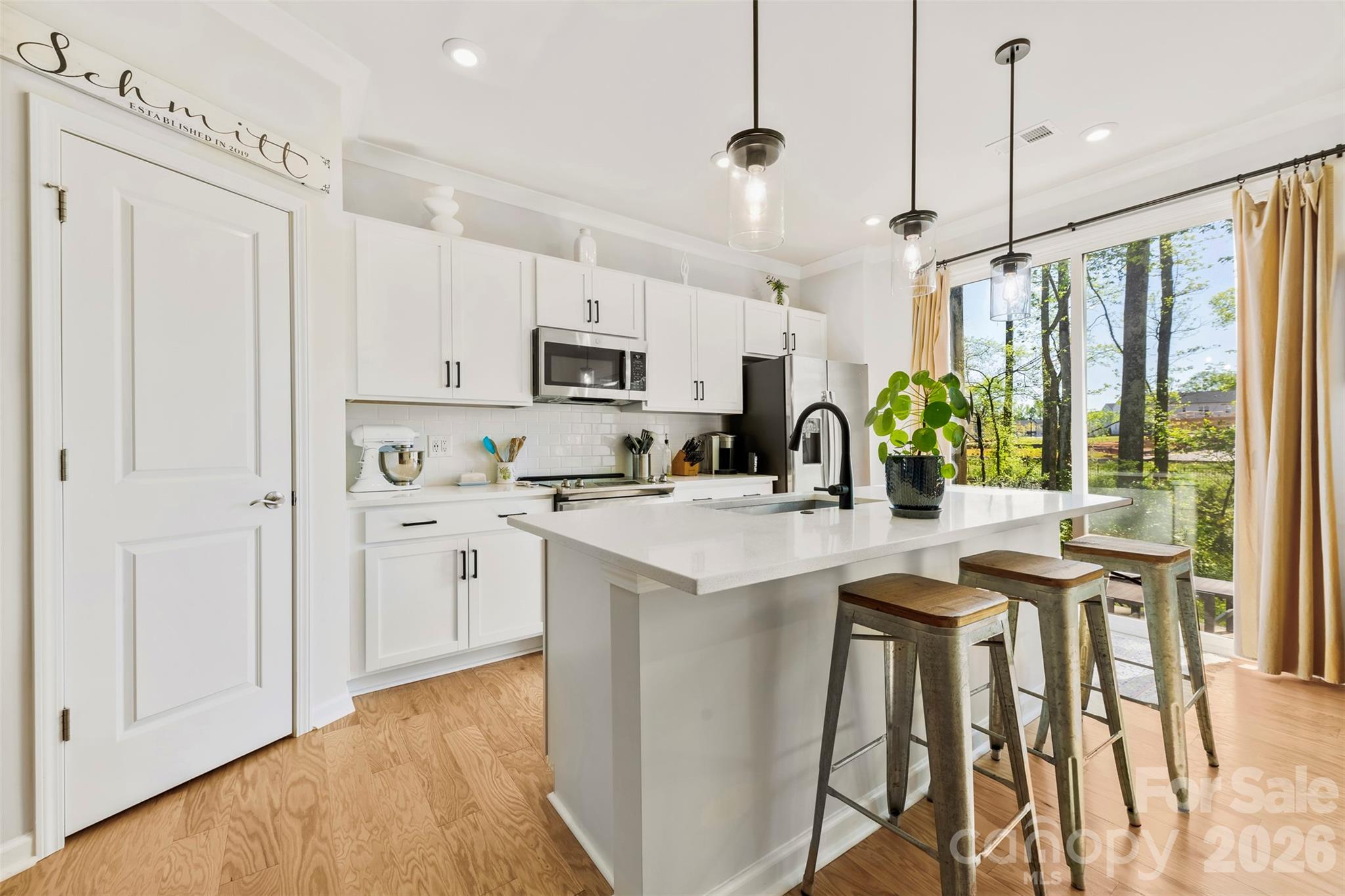 SKIP THE WAIT FOR CONSTRUCTION! Move-in ready townhome with privacy as a premium end unit, located in a vibrant new development. Tucked away in a quiet cul-de-sac, this gem is bathed in abundant natural light. No neighbors directly behind this lot. Step inside this stylish 3-bedroom, 2.5-bath townhome to find an open floor plan designed for today’s lifestyle. The main level flows seamlessly from a spacious living area into a designer kitchen, featuring modern finishes, beautiful cabinetry, and generous counter space; this kitchen makes both everyday living and entertaining effortless. Owner upgrades: ceiling fans have been added to the living room, primary suite, and guest bedroom for year-round comfort; the garage features a custom work bench with dedicated power from an additional garage outlet plus heavy-duty suspended garage shelving for more storage capacity; built-in shelving has been added to the pantry and two additional closets, maximizing organization throughout the home. Situated in the 28269 zip code, you are positioned for a quick commute to Uptown Charlotte, NoDa, Camp North End, University City, and other major regional employment and entertainment hubs. Enjoy easy access to I-77 and I-85, as well as local shopping, dining, and entertainment. Great opportunity to own a home in a growing part of town! This property may qualify for 100% financing, combined with 2 incentives from a preferred lender (a grant from the lender of up to $5,000 for closing cost assistance and up to $5,000 for down payment assistance).