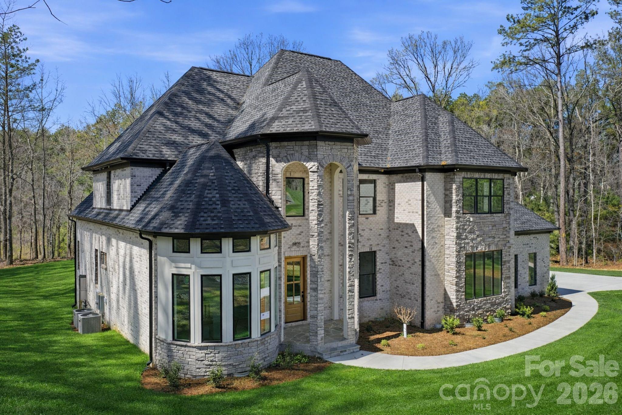 Tucked away on a private, wooded 1.759-acre corner homesite within the gated community of Riverchase Estates, this custom residence offers a rare blend of architectural presence, refined finishes, and elevated lifestyle living.

With 3,867 square feet of thoughtfully designed space, this 4-bedroom, 4.5-bath home was curated for those who appreciate both sophisticated design and everyday comfort.

From the moment you arrive, the stately stone façade, soaring rooflines, and expansive driveway create a striking first impression—setting the tone for what awaits inside.

Step through the entry into a dramatic two-story great room, where natural light pours through French doors, highlighting the fireplace and creating an inviting and warm gathering space.

The heart of the home is a beautifully appointed kitchen featuring luxury GE Monogram appliances, an oversized island, and custom cabinetry throughout—perfectly designed for both entertaining and everyday living.

The primary suite is a private retreat, complete with a cathedral ceiling and windows that flood the space with natural light while offering serene views of the wooded backyard.

Designed for flexibility and comfort, the home also features a dedicated office with oversized windows, a spacious bonus room with its own half bath, entertainment bar, and beverage refrigerator—ideal for hosting or creating a private escape. 

Enjoy unparalleled convenience with a massive walk-in storage suite, eliminating the need for pull-down stairs while keeping your belongings organized and accessible.

Seamless indoor-outdoor living continues onto the screened porch with a fireplace, overlooking a private, pool-ready backyard—offering endless possibilities for creating your own outdoor oasis.

Beyond the home, Riverchase Estates delivers an unmatched lifestyle experience, featuring a stunning $2 million clubhouse with resort-style outdoor pool, fitness center, ball courts, playground, and a beautifully designed reception space perfect for hosting or catering large events. Residents also enjoy scenic walking trails that lead to the Catawba River, blending luxury living with natural beauty.

This is more than a home—it’s a lifestyle defined by privacy, warmth, and community.