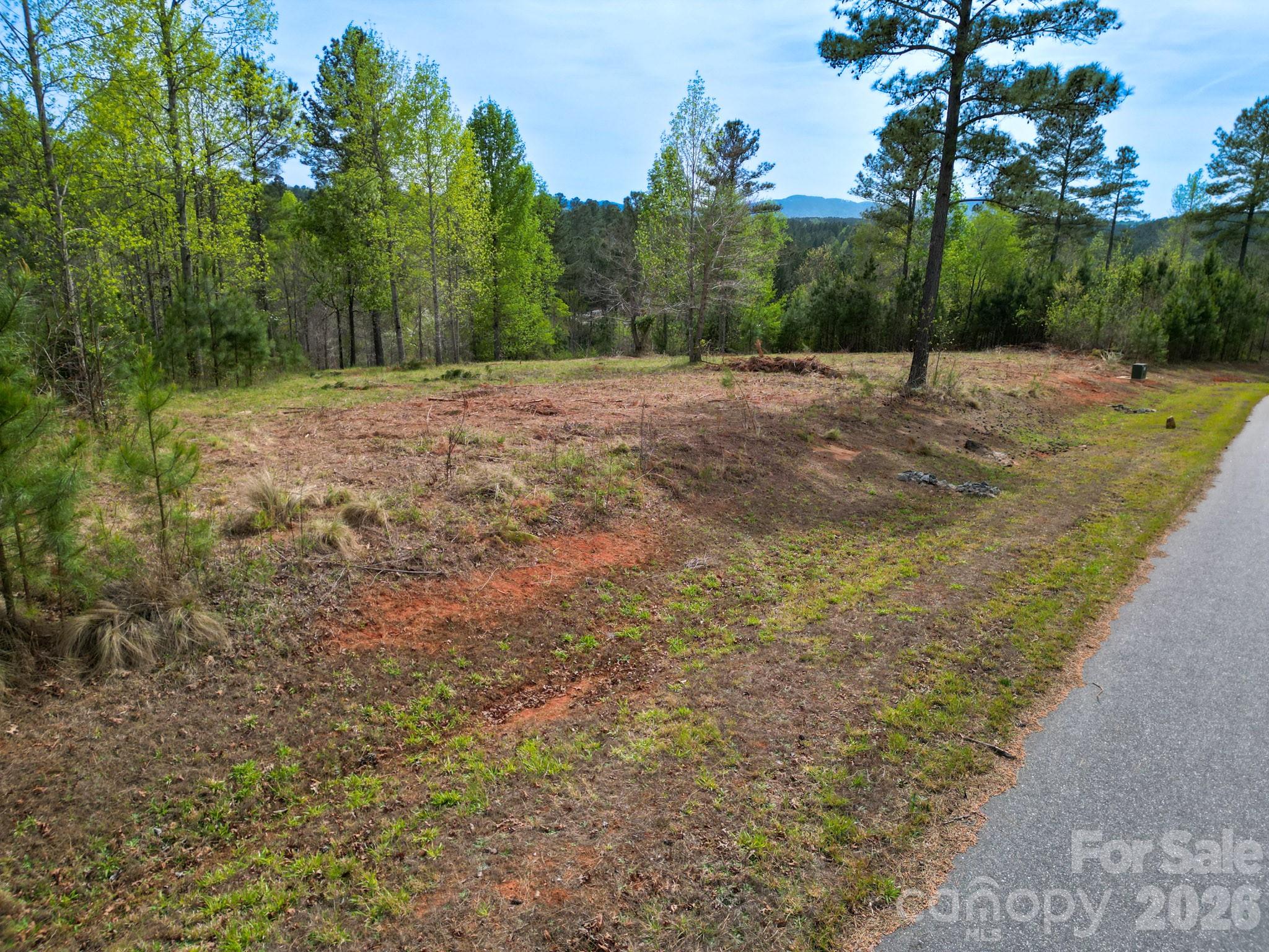 Positioned within the gated Lake Vistas community, this private lot offers the opportunity to build with intention—whether you’re envisioning a full-time residence or a quiet mountain-area retreat. Set among rolling terrain with paved road access, the property provides both ease and a sense of seclusion. A 1,700 sq ft minimum allows flexibility in design, while underground utilities and low HOA dues help protect long-term value. Located at Lake Rhodhiss, you’ll enjoy the community area at the lake, quick access to boating, fishing, and year-round outdoor recreation on one of the region’s most sought-after lakes, known for its exceptional water clarity. Conveniently situated near Valdese, Hickory, and I-40, this homesite offers a rare balance of privacy, natural beauty, and accessibility. A thoughtful setting for your next chapter, without compromise.