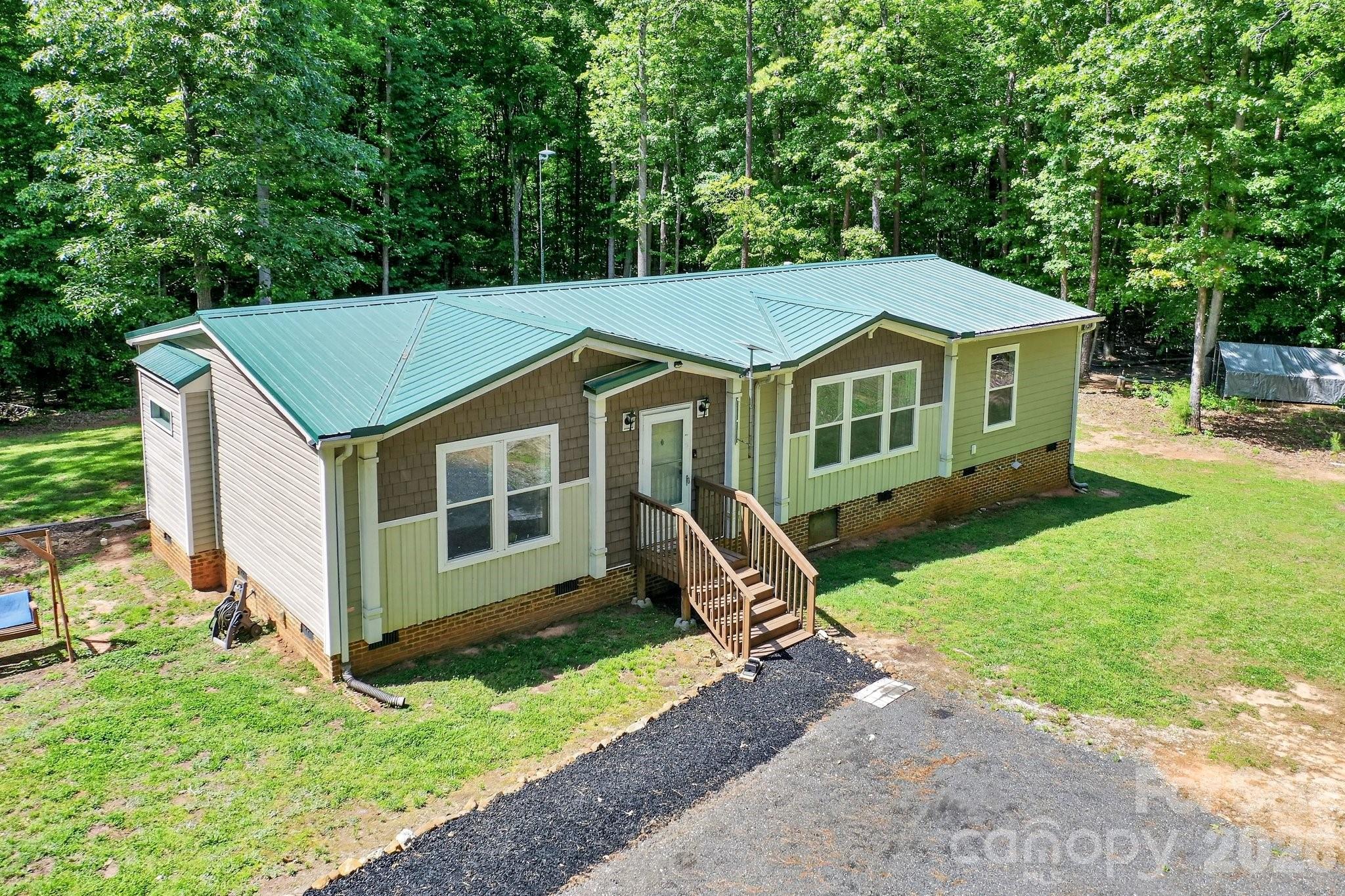 Craving space, privacy, and freedom from HOA restrictions? Welcome to your private retreat on 14 serene acres surrounded by mature hardwoods. Built in 2017, this charming 3-bedroom, 2-bath home offers a thoughtfully designed split floor plan with inviting, comfortable living spaces throughout. A recently added 30x35 detached garage/shop is wired and ready for your hobby or small business needs. Within the last two years, this home has received all new HVAC, flooring, kitchen appliances, paved driveway, and structural improvements. The heart of the home is a spacious eat-in kitchen featuring a center island, pantry with a stylish sliding barn door, and plenty of room to gather. An oversized laundry and craft room adds extra flexibility for hobbies, storage, or workspace needs. The owner’s suite is a true escape—bright and airy with soft neutral tones, a spa-inspired bathroom complete with an oversized tiled shower, and a separate soaking tub perfect for unwinding. Step outside and take in the peaceful surroundings from the large deck with included patio set—ideal for relaxing or entertaining while overlooking your own private sanctuary. A durable raised-seam metal roof was installed in 2022 for added peace of mind.