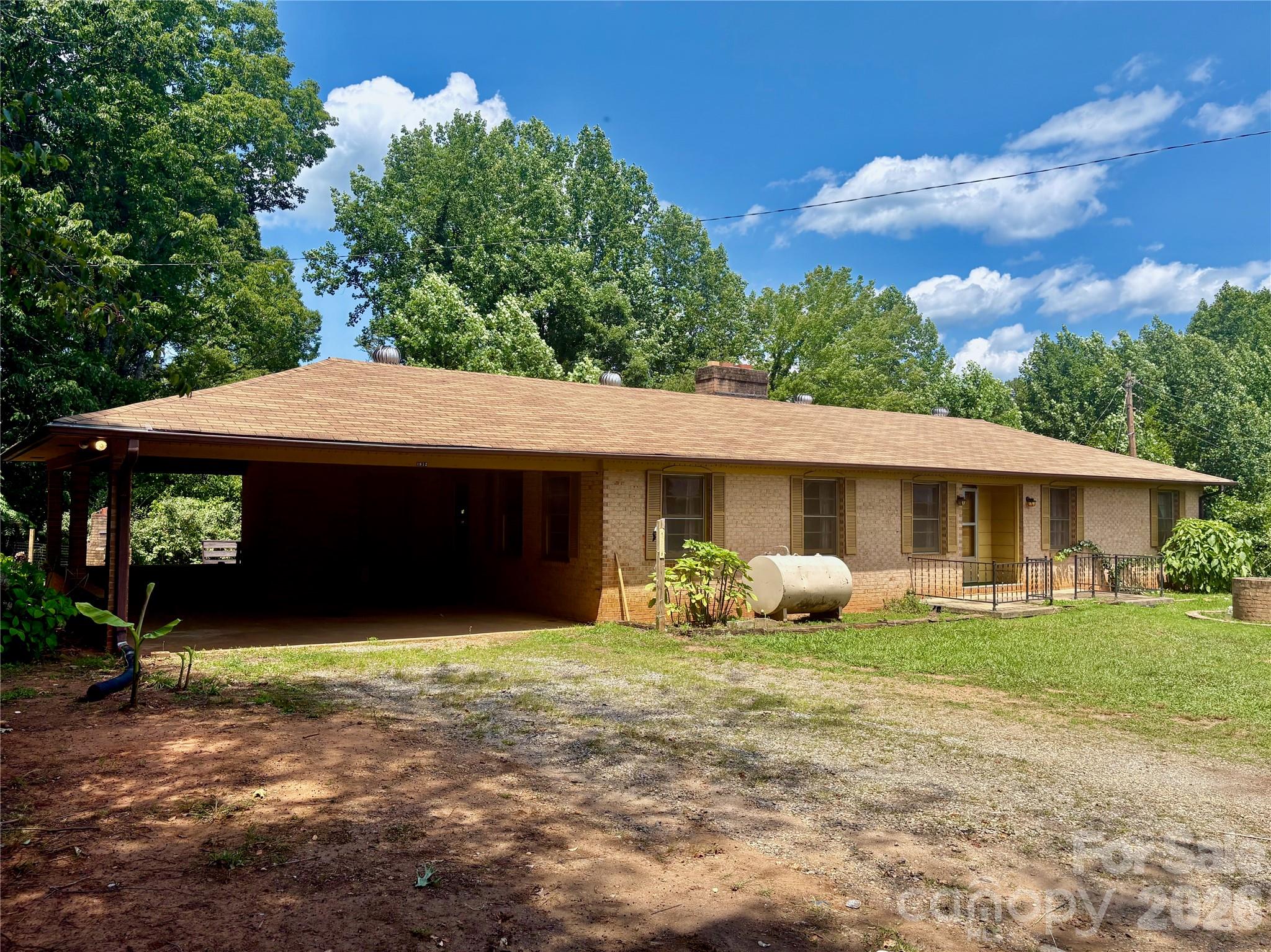 Nestled on approximately 3.36 private acres, this one-level brick home offers a peaceful setting surrounded by nature, featuring 3 BR, 2 baths, includes living room, family room, den, dining room & more, brick fireplaces,  2-car carport, located just 20 minutes from Lake Lure Beach, this home combines a tranquil country setting with easy access to recreation and amenities, offers an excellent opportunity to update and make your own!