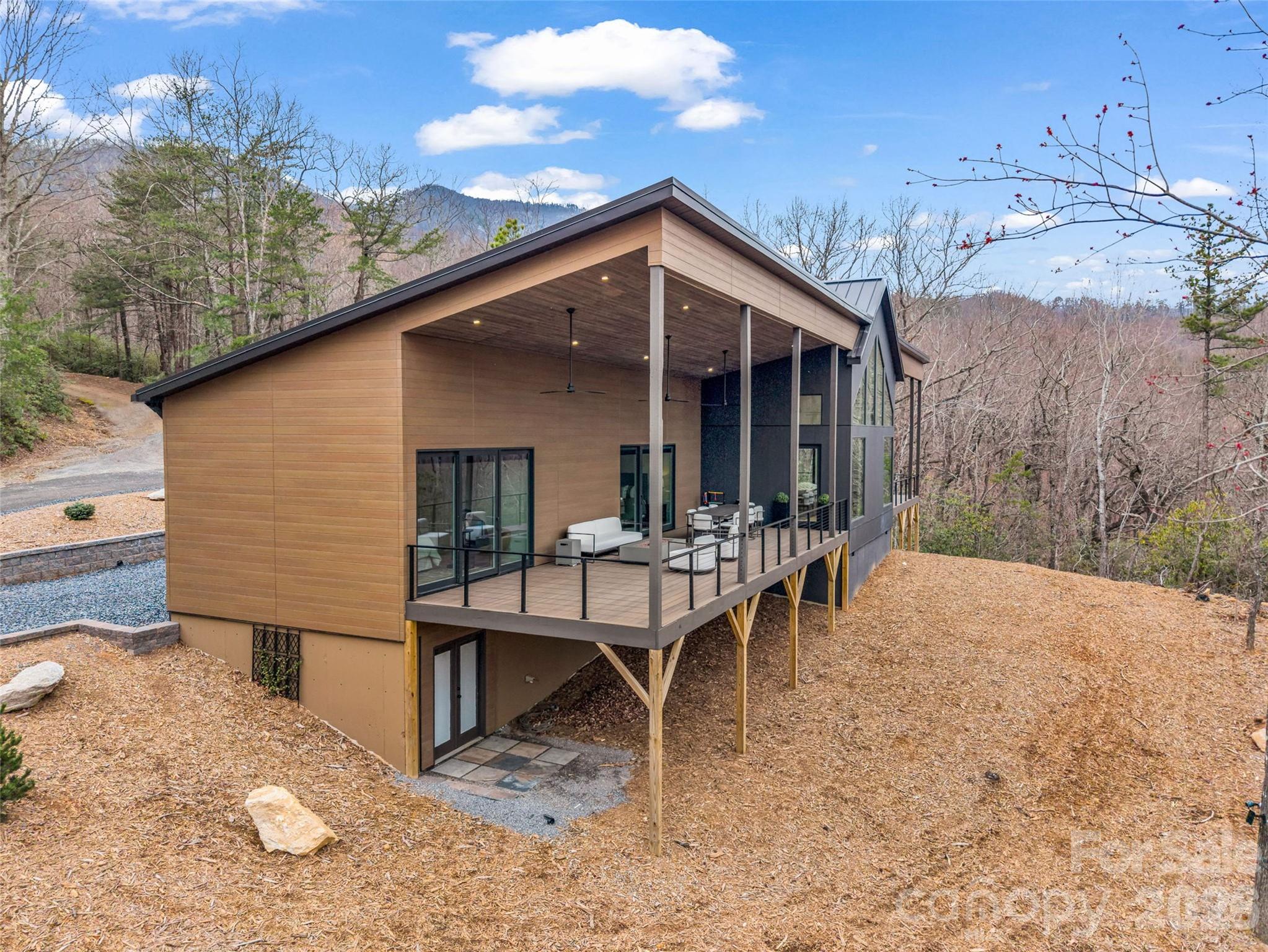 Experience the peak of modern mountain luxury in this stunning masterpiece at Rumbling Bald on Lake Lure.  A showcase of exceptional design and craftsmanship, this home features meticulously curated, high-end finishes—each detail thoughtfully selected to deliver both refined beauty and outstanding performance. From the moment you arrive, the home makes a striking impression with its clean lines, cutting-edge Japanese CERACLAD siding, and architectural elegance. Step inside to discover a light-filled, open-concept layout where expansive windows and sliding glass doors invite the outdoors in, framing serene wooded and mountain views. At the heart of the home, the designer kitchen blends sophistication with everyday functionality. Featuring custom matte black GE CAFÉ appliances with brass hardware, an induction cooktop, Diamond Advanced all-wood matte cabinetry, and sleek Shadow Gray quartz countertops, the space is anchored by an oversized island—perfect for gathering, entertaining, and effortless living. A highly desirable split-bedroom floor plan offers both privacy and versatility, featuring three spacious bedrooms, each with its own ensuite bath, plus an additional half bath for guests. Wide-plank European white oak flooring flows throughout, complemented by luxurious Krion bath fixtures and stunning large-format porcelain tile imported from Spain—creating a seamless fusion of European elegance and modern mountain design. The primary suite serves as a private retreat, featuring a spa-inspired bath with floating vanities and a beautifully appointed walk-in shower designed for ultimate relaxation. Outdoor living is equally impressive, with expansive decking ideal for peaceful mornings and unforgettable evenings under the stars. Whether sipping coffee surrounded by nature or hosting guests, this home captures the essence of elevated mountain living. Constructed with quality and efficiency in mind, the home includes advanced systems, superior insulation, and premium construction elements, ensuring year-round comfort and low-maintenance living.   As part of the Rumbling Bald community, residents enjoy access to world-class amenities including championship golf, private lake access, wellness facilities, dining, and endless outdoor recreation.  This is more than a home—it’s a statement of elevated living in one of Western North Carolina’s most sought-after lake and golf communities.  Discover the perfect balance of innovation, luxury, and serenity at Rumbling Bald on Lake Lure.