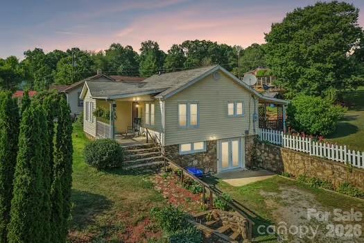 Nestled in the peaceful mountain community of Clyde, with organic snapdragons coming out of steps and stone work each year will splatter your home with color.. 120 Caring Place Loop is a charming bungalow that blends timeless character with thoughtful updates. This inviting 2-bedroom, 1-bath home features original hardwood floors, a welcoming front porch, and beautiful stonework that reflects its classic 1942 craftsmanship.

The bright spacious kitchen, complete with a generous island, is ideal for gathering with family and friends. A finished lower level offers flexible bonus space for a home office, recreation room, or hobby area, while the generous fenced yard, mature landscaping, and mountain views create a relaxing outdoor retreat.  

Conveniently located just minutes from Waynesville, Maggie Valley, and approximately 20 minutes from Asheville, this home offers the perfect balance of quiet country living and easy access to shopping, dining, and outdoor recreation. Whether you’re looking for a full-time residence, mountain getaway, or investment opportunity, 120 Caring Place Loop delivers warmth, charm, and the natural beauty that makes Western North Carolina so inviting.