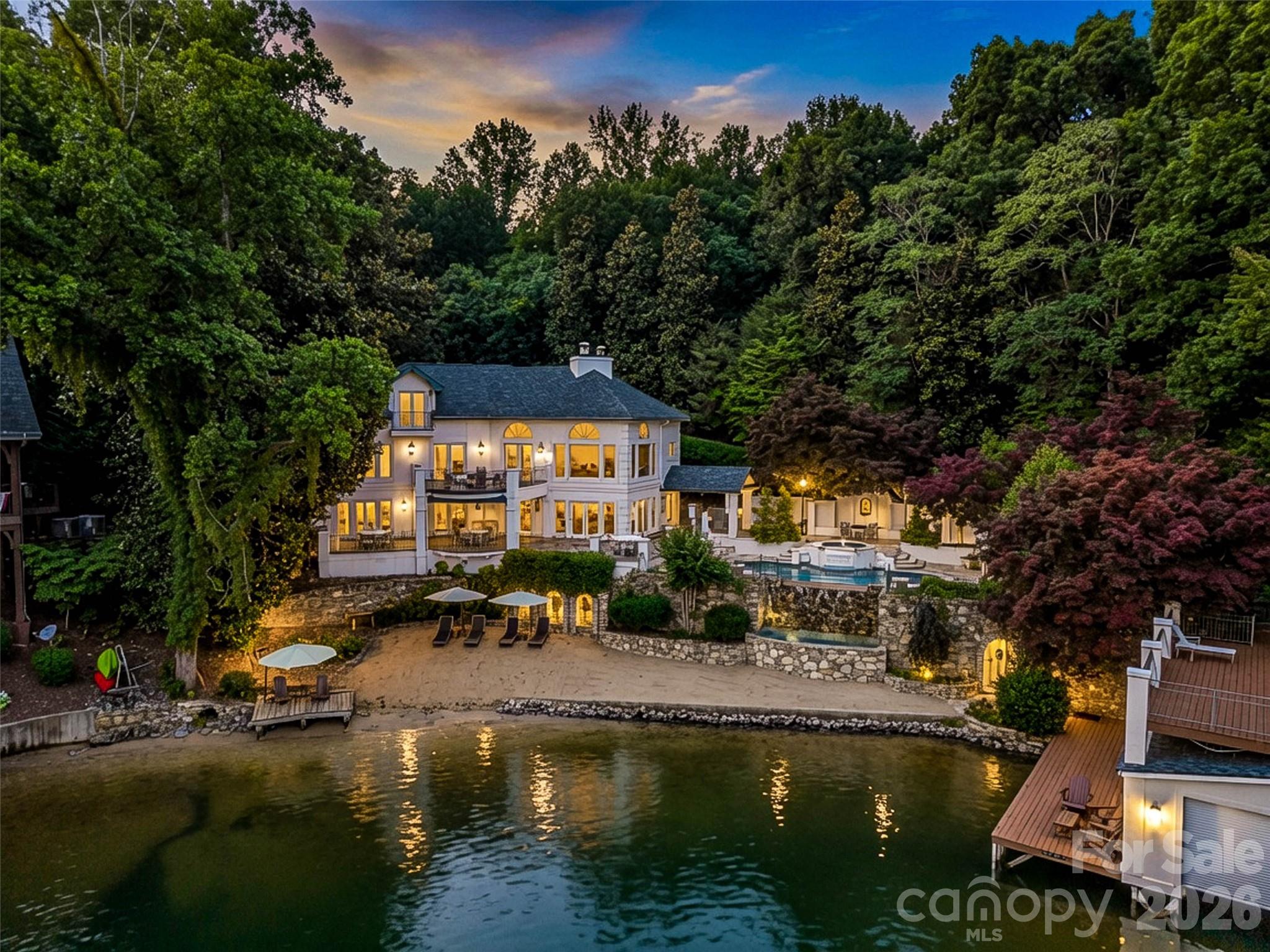 Welcome to historic Villa Rosa! One of Lake Lure's most iconic waterfront estates. Back
on the market and better than ever, this extraordinary lakefront residence has been
thoughtfully reimagined with a stunning new gourmet kitchen redesigned for effortless
entertaining and alfresco dining, beautifully renovated spa-inspired bathrooms, and
sophisticated modern updates that honor its timeless architectural character. Spanning
more than 4,500 square feet, Villa Rosa features five luxurious ensuite bedrooms, each
with its own beautifully redesigned spa-inspired bathroom complete with designer tile,
premium fixtures, and elegant finishes. A newly reimagined gourmet chef's kitchen
features an expansive quartz island, designer appliances, and custom cabinetry,
seamlessly blending contemporary luxury with historic charm. Expansive balconies and
terraces frame breathtaking panoramic views of Lake Lure, inviting you to experience
the beauty of every season. Step outside to your own private waterfront paradise where
every day feels like a vacation. Relax beside the heated ionic infinity-edge waterfall
pool, unwind on your private sandy beach, or enjoy effortless lake living from the fully
remodeled double boathouse with its expansive waterfront entertaining deck taking in
the surrounding mountain views. Villa Rosa is more than a home—it's a legacy. Offering
direct lake access, exceptional craftsmanship, unparalleled outdoor living, and one of
the most recognizable addresses on Lake Lure, this is a once-in-a-generation
opportunity to own a truly iconic waterfront estate.