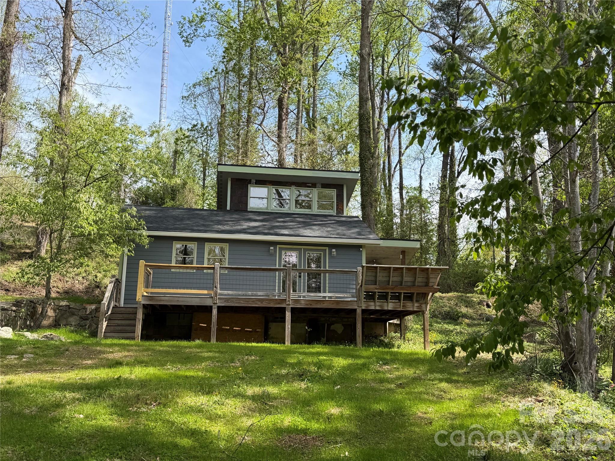 Nestled on a peaceful, sun-filled lot surrounded by mature trees, this thoughtfully updated home offers privacy, character & convenience just minutes from Downtown Hendersonville. Enjoy easy access to Main Street dining, shopping, entertainment, and outdoor recreation while benefiting from county only taxes.  Easy drive to hwy 26 for drive to Asheville area.
Renovated throughout, the home features updates including a new roof, mini-split heating system, updated lighting, appliances, fresh interior paint, some new flooring, updated kitchen counters, sink, fixtures, and bedroom ceiling fan. Warm wood accents, abundant tile work & custom kitchen island add charm and functionality throughout the space.
The bright open concept layout creates an inviting flow between the kitchen and living area, ideal for everyday living or entertaining. Generous pantry storage with lots shelving & lighting.   Kitchen direct access to the covered side porch for seamless indoor /outdoor living. Additional hidden storage spaces throughout the home.
The bathroom includes a beautifully tiled walk-in shower, while the upstairs bedroom offers a bright and airy retreat complete with additional eave and closet storage.
Outside, enjoy a blend of open sunny yard space and natural wooded privacy. The property offers plenty of room for gardening, outdoor gatherings, relaxing around a fire pit, or creating your own mountain retreat. The welcoming front deck provides a peaceful setting to enjoy sunshine and seasonal winter views.
The property experienced damage during Hurricane Helene; however, nearly all interior components, appliances and finishes have since been renovated or replaced, resulting in a fresh, updated living space with modern improvements throughout.