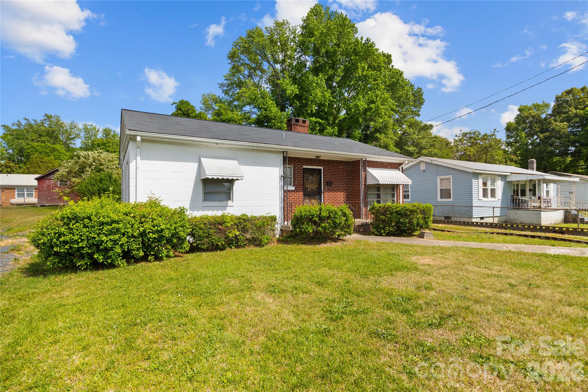 This charming 1959 ranch-style home offers a nostalgic blend of mid-century character and functional living space in the heart of Troy. The exterior features classic accented red brick and vintage awnings, creating an inviting first impression. Inside, the home boasts a versatile layout including both a formal living room and a cozy family room or den, highlighted by warm wood-paneled walls, a brick accent wall, and a traditional wood-burning stove—perfect for creating a snug atmosphere during cooler months.

The kitchen is a retro enthusiast's dream, showcasing original knotty pine cabinetry with unique decorative hardware, ample counter space, and integrated appliances that maintain the home's authentic period feel. Practicality meets convenience with a notably large laundry room and a 1.5-bath configuration that serves three bedrooms. For those who enjoy outdoor living or need extra space for hobbies, the property includes a semi-private backyard and a garage that is ideally suited for a workshop or additional storage. Roof, Electrical & Heat Pump unit updated between 2015-2020. This well-preserved residence is a fantastic opportunity for anyone looking to embrace classic 1950s design while living close to local amenities.