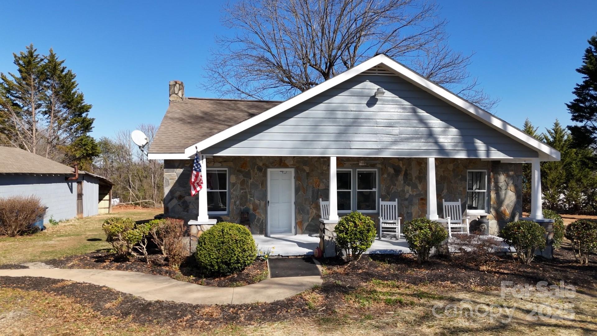 Check Out This Charming & Cozy Stone Cottage built in the 1940's... But with all of the modern day updates & finishes! The farm-house style kitchen boasts beautiful Quartz Countertops, under cabinet lighting, a chefs Range Hood, new cabinets, new appliances & a trough sink.  Off of the kitchen is a large laundry room that can double as a mud room and pantry storage.  All new laminate LVP flooring throughout the home. Full bath has a barn door - & quartz countertops.  Across the front of the home is a wide & wonderful porch looking out over the 2.2 acre corner lot!  Got Cars? This home has room for 5 cars and your "toys"!  Whether you are a mechanic needing a place for your business, or a workshop for your hobbies, this property has it all.  Building has 220 power for your tools.  Two year old septic tank; home is on a well, but public water is available, the sale includes 2 parcels - Roof is 11 Yrs old - This home is move-in ready!!