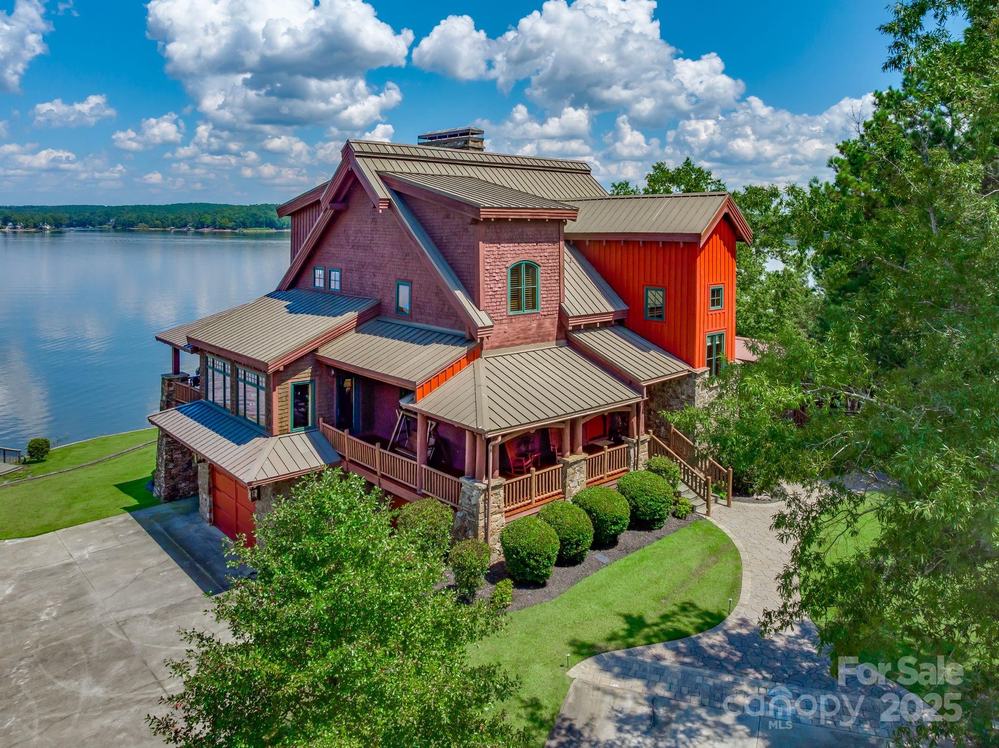 Premier Lakefront Estate on Lake Wateree – Now Even More Extraordinary!

Experience the pinnacle of luxury lakefront living at Rockbridge Lodge — a breathtaking retreat that has just become even more exceptional. The property now includes an additional 1.37-acre sandy beach lot right on the main channel. Together, this brings the total waterfront property to 3.12 acres of pristine, private paradise — dramatically expanding your personal waterfront haven.

As you arrive, the lodge's impressive stone-and-timber facade commands attention, blending rustic elegance with timeless grandeur. Step inside to the soaring grand room, where a massive wood-burning stone fireplace anchors the space beneath dramatic timber-beam ceilings. This isn't just a home — it's a resort-like escape designed for unforgettable moments.

The luxurious master suite serves as your private sanctuary, featuring its own cozy wood-burning stone fireplace, expansive windows and doors framing stunning sunrise views across the shimmering lake, a generous walk-in closet, and a spa-inspired bathroom complete with a separate shower and relaxing jacuzzi tub.

Up the grand timber stairwell, additional bedrooms await, each with soaring ceilings and clever hidden nooks or lofts — perfect for extra sleeping space or playful hideaways. The home boasts three fireplaces in total, including one in a guest bedroom for added warmth and charm.

The lower level is an entertainer's dream: a versatile, expansive space with multiple seating areas, a pool table, game table, ping-pong, and a state-of-the-art HD projector with a 12-foot screen. Step outside through dramatic, arch-shaped castle-like doors to a large concrete apron — ideal for parking, outdoor gatherings, or overflow entertaining. A walk-in concrete vault offers endless possibilities, from a custom wine cellar and tasting
room to secure storage for the avid hunter's collection. The adjacent theatre room, with its stone walls and coffered ceiling, elevates movie nights to cinematic heights.

Outside, the amenities continue to impress: a large treehouse, boathouse, private boat ramp, RV hookups, irrigation system, and so much more.

This rare gem on one of South Carolina's most sought-after lakes delivers unmatched value and endless possibilities. Don't let this upgraded masterpiece pass you by — schedule your private tour today and discover your forever lakefront legacy!