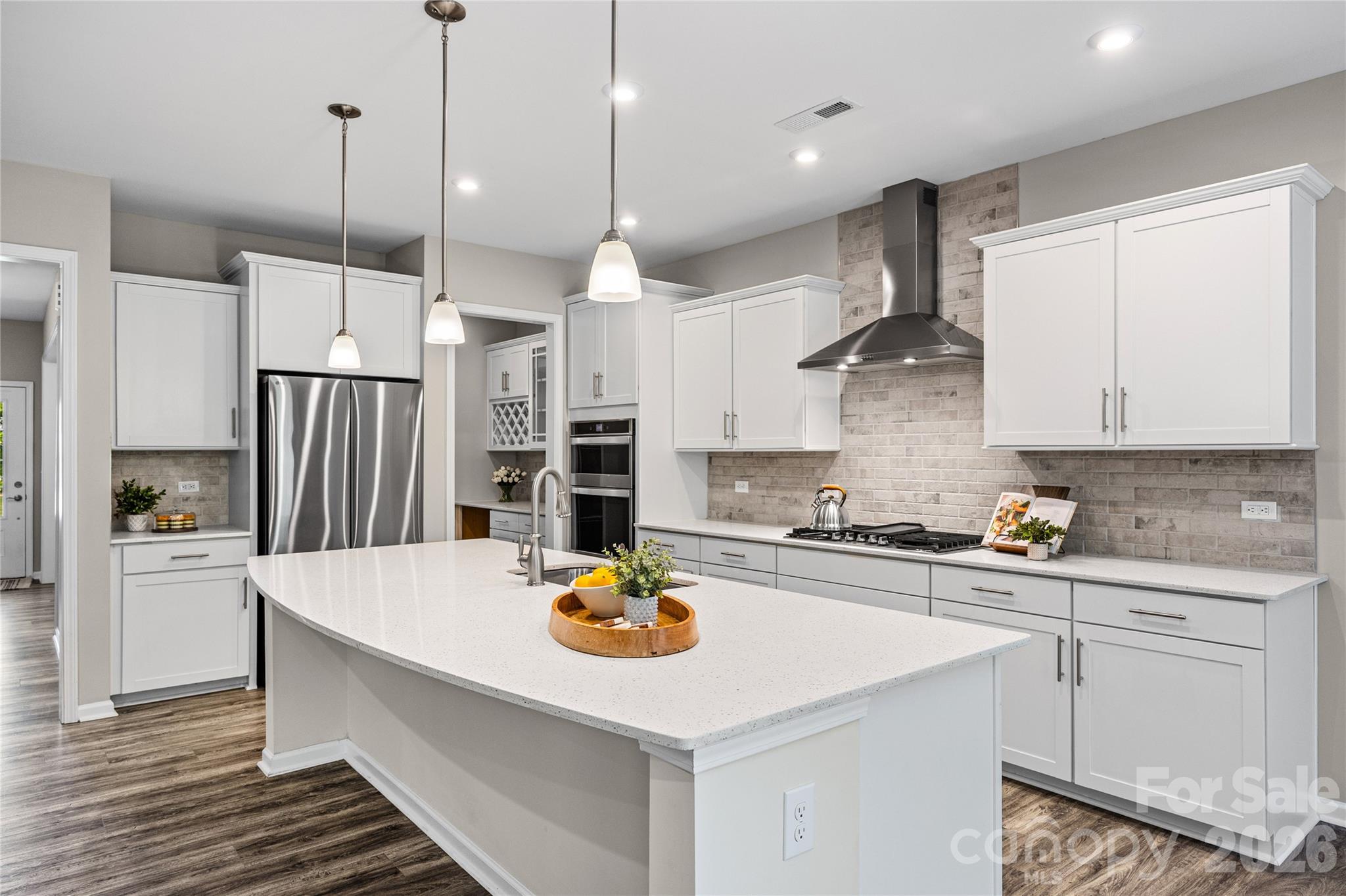 A rare find, this McCullough home with a basement backs to a stunning wooded view, and just a couple houses down from one of the community pools! From the moment you enter the covered front porch, you'll notice the fresh paint throughout the entire home, and luxury vinyl plank flooring that runs on the entire main level. You are flanked by a dining room with a tray ceiling and an office with french door. A butlers pantry with space for a beverage refrigerator gives way to a chef's kitchen, with all the details - expansive quartz counters, gas range with stainless steel hood, large walk-in pantry, backsplash to the ceiling, and more! The breakfast area opens to a deck, perfect for grilling or enjoying the treed backdrop. The great room is centered by a cozy gas fireplace with stacked stone details. You'll also find a flex space off the garage, ideal for a drop zone station, additional office or workspace, and extra storage. As you head upstairs you'll find a generous primary suite with a large walk-in closet, and a bathroom with dual vanities, a walk-in shower with a rainfall shower head, a bench, and tile to the ceiling. Another 3 bedrooms, a full bathroom, a laundry room, a large loft space, and walk-in attic storage round out the upstairs. Head to the basement and you'll be amazed with all of the extra space—an expansive recreation room for multi-use, a full bathroom, and tons and tons of unfinished storage areas! As you head outside onto the lower level patio, you'll find a peaceful backyard with this exterior facing lot - plus full irrigation for easy maintenance. And don't miss the amenities - McCullough is a lifestyle rich community with 2 pools (one just 2 lots down), sport courts, a dog park, many open green spaces, near downtown Pineville with a new greenway access trail - welcome home!
