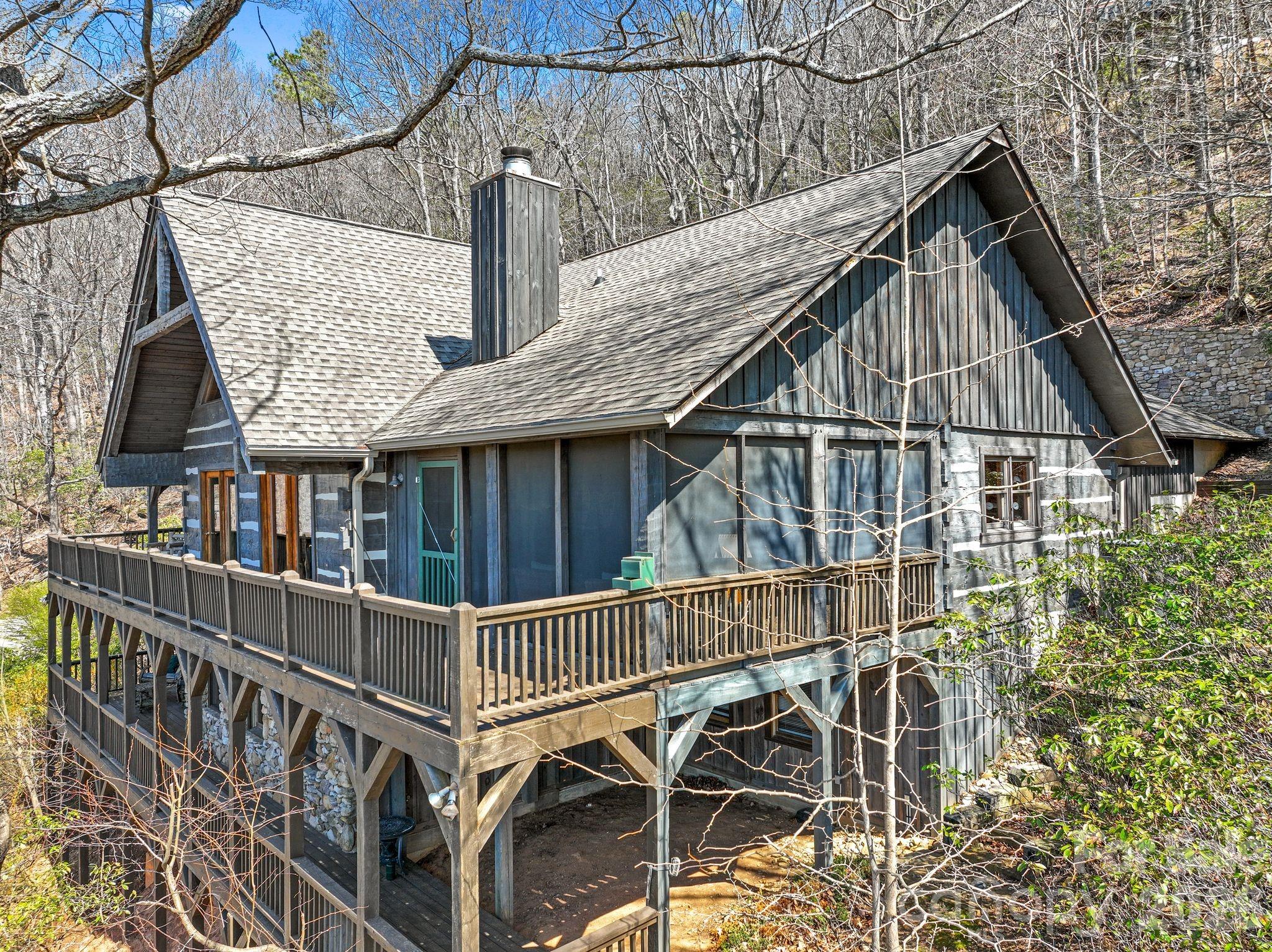 Now offered at an exceptional value in High Vista. Perched at approximately 2,700 feet in elevation within the gated High Vista community, this beautifully maintained Bob Timberlake hemlock log home captures sweeping, layered views of the Blue Ridge Mountains and the quiet magic of mountain living. Set on .85 acres along a peaceful ridge, the home offers a rare combination of privacy, craftsmanship, and year-round scenery that changes with every season.

Built with impressive solidity and anchored into bedrock, the home reflects the warmth and authenticity of classic Timberlake design. Inside, rich wood tones, vaulted spaces, and large windows frame the surrounding mountains and invite the outdoors in. The atmosphere feels like a true mountain lodge retreat—warm, welcoming, and perfectly suited for both quiet mornings and lively evenings with friends.

The heart of the home opens to a spectacular screened porch and expansive rear deck stretching across the back of the house, creating the perfect setting for morning coffee, sunset dinners, or simply watching the clouds drift across the distant ridgelines. A thoughtfully placed fire pit area offers another inviting place to gather and enjoy the mountain air beneath the stars.

The kitchen features recently updated appliances, while the home has been meticulously cared for throughout, including exterior staining in recent years and a recently installed tankless water heater. The daylight lower level provides additional living space ideal for guests, recreation, or a quiet retreat. Additionally, each bedroom in the home features an ensuite bathroom and a mountain view.

Wildlife is part of everyday life here—deer often wander along the ridge and the surrounding woods create a peaceful natural backdrop that feels far removed from the pace of town, yet you are only minutes from Hendersonville, Asheville Regional Airport, and the restaurants and shopping of the area.

Located within High Vista, residents enjoy access to a vibrant mountain community featuring optional amenities membership and 3 levels of golf memberships, a clubhouse and restaurant, racquet courts, swimming pool, and an active calendar of events.

Don't miss your opportunity to own one of the most thoughtfully designed log homes in the area! Exquisite furnishings are negotiable. DON'T MISS THE VIDEO TOUR - click on the link. https://www.youtube.com/watch?v=fal_Bs0Zuh8