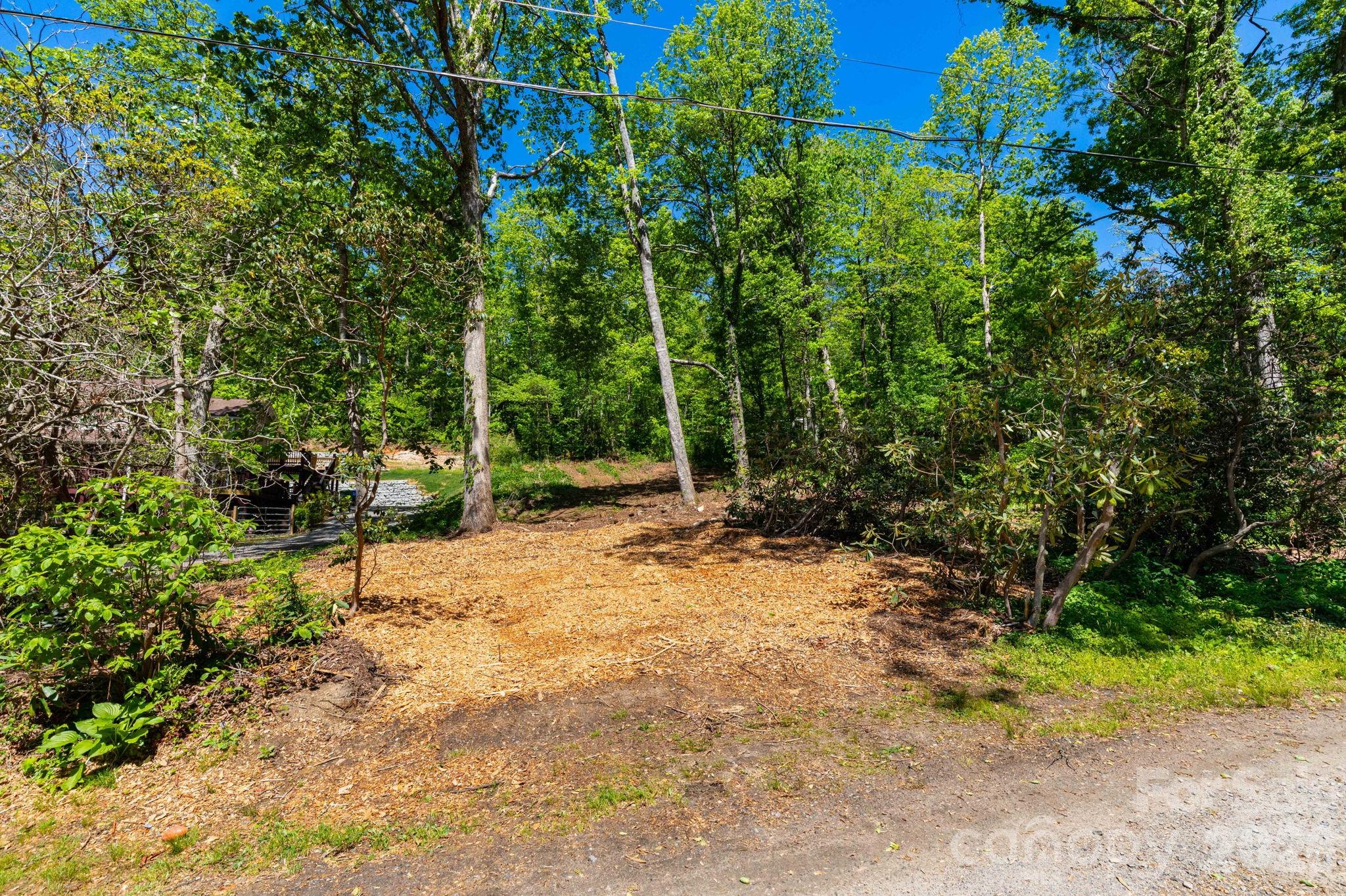 Currently configured as two separate lots, this property may offer greater potential when combined into a single homesite. A well will be needed, though access to MSD sewer is available.

The lower lot features easy access from a publicly maintained road and a cleared, level build site—ideal for a straightforward build. The upper lot presents an opportunity for enhanced views with selective tree clearing, though the steeper topography would likely lend itself best to a basement foundation.

Just under half an acre in one of Western North Carolina’s most sought-after areas, this unrestricted property gives you the flexibility to build what you want, how you want. Enjoy space for a home and yard, city sewer access, and close proximity to everyday conveniences.

Located just 5 minutes from downtown Black Mountain and under 20 minutes to Asheville, you get the perfect balance of accessibility and mountain charm. Outdoor enthusiasts will appreciate nearby trail systems and quick access to the Blue Ridge Parkway.

Bring your vision and make it your own. A builder familiar with the property is available for consultation upon request.