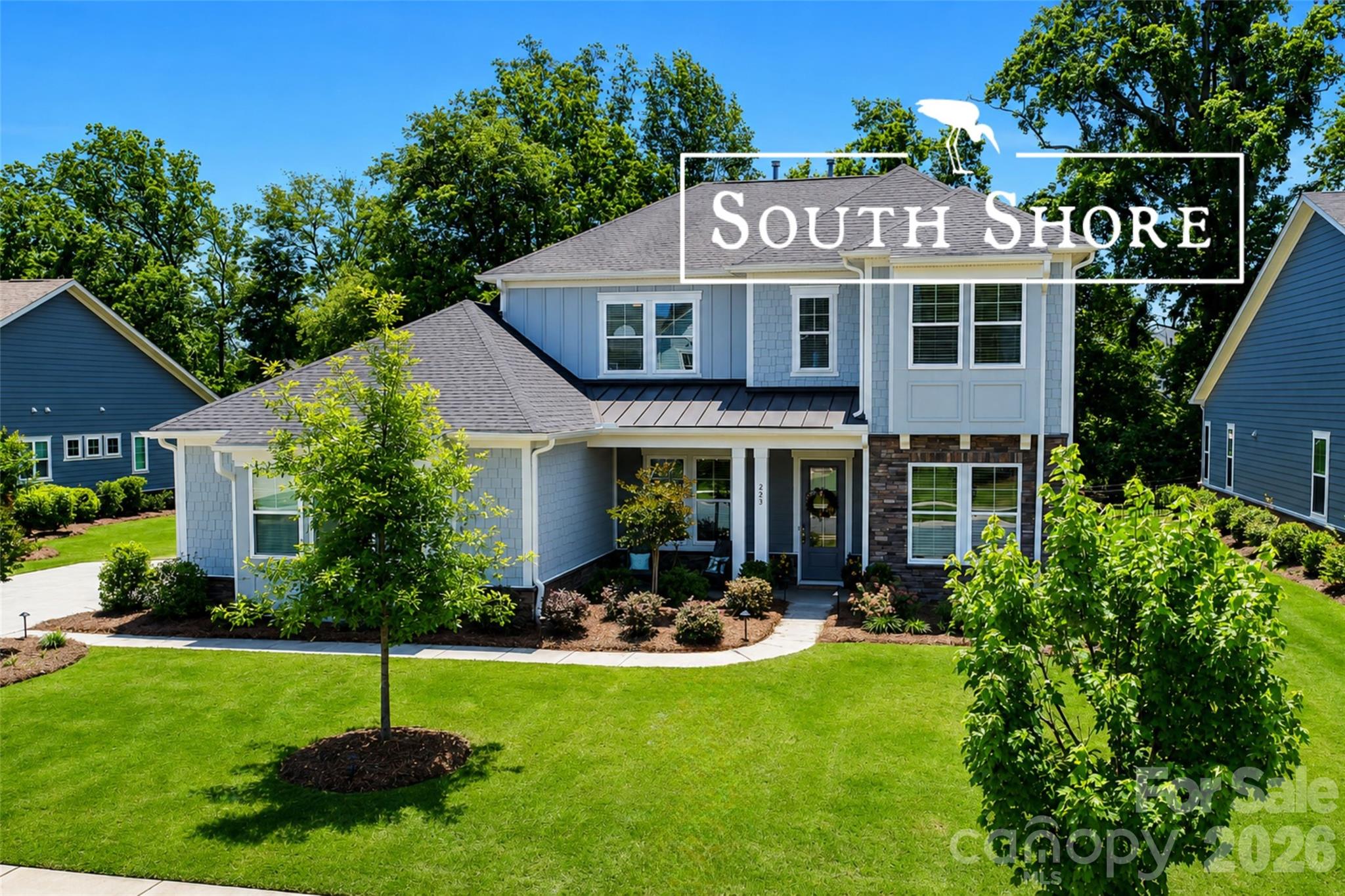 Stylish South Shore Sanctuary with Spectacular Outdoor Living

Lake living, luxury, and exceptional entertaining converge at 223 Lanyard Lane in Belmont’s highly sought-after waterfront community of McLean – South Shore.

Beautifully upgraded and thoughtfully designed, this stunning home offers the perfect blend of elegance, comfort, and resort-style living just moments from Lake Wylie. Filled with natural light and upscale finishes throughout, the open-concept layout creates inviting spaces for both everyday living and unforgettable gatherings.

At the heart of the home, the gourmet kitchen features quartz countertops, a direct-vent chimney-style hood, quality finishes, and seamless flow into the spacious living and dining areas. Just off the dining space, a built-in home office creates a convenient secondary workspace or homework station — ideal for today’s flexible lifestyle alongside the home’s primary office space.

The luxurious owner’s suite feels like a private retreat, highlighted by a dramatic 42” linear fireplace and a spa-inspired bath featuring a soaking tub, oversized walk-in shower with dual-side access, and elegant finishes throughout. The suite also offers direct access to the laundry room — a thoughtful design feature that blends luxury with everyday convenience.

Additional interior upgrades include oak box stairs with stylish metal balusters, ceiling fans throughout, a Rinnai tankless water heater, rain shower upgrade, frameless glass shower enclosure, and beautifully appointed living spaces designed for both comfort and sophistication.

The outdoor living experience is equally impressive and was clearly designed as a true extension of the home itself. Backing to a peaceful wooded setting, the fully fenced backyard offers both privacy and beauty, enhanced by expansive pavered entertaining spaces, low-voltage landscape lighting, and a custom stone-step stairwell leading to the rear of the property.

The screened porch and patio area create an incredible year-round retreat featuring a cozy outdoor fireplace with TV wiring above the mantel, natural gas supply, ceiling fan, and elegant paver flooring — perfect for football Saturdays, quiet evenings, or entertaining guests. The fully equipped summer kitchen elevates the experience even further with a premium Napoleon grill, separate sear burner, stainless cabinetry, beverage refrigerator, sink with hot and cold water, and both natural gas and electrical connections already installed.

Car enthusiasts and storage lovers alike will appreciate the impressive 3-car garage configuration, featuring a side-load 2-car bay plus an additional front-load single bay, all enhanced by premium epoxy-coated flooring for a clean, polished finish.

Beyond the home itself, McLean – South Shore offers one of the most desirable lifestyle experiences in the region, featuring a stunning clubhouse, resort-style pool, playground, scenic walking trails, and easy access to the Carolina Thread Trail system and nearby Daniel Stowe Botanical Garden. Residents enjoy the perfect blend of nature, recreation, relaxation, and convenience — all just minutes from charming downtown Belmont, waterfront dining, shopping, and an easy commute to Charlotte.

Whether it’s lake days, evenings around the fire, morning walks beneath the trees, or gathering with neighbors by the pool, life at South Shore feels like a permanent retreat.

“Home should feel like your favorite getaway.”
