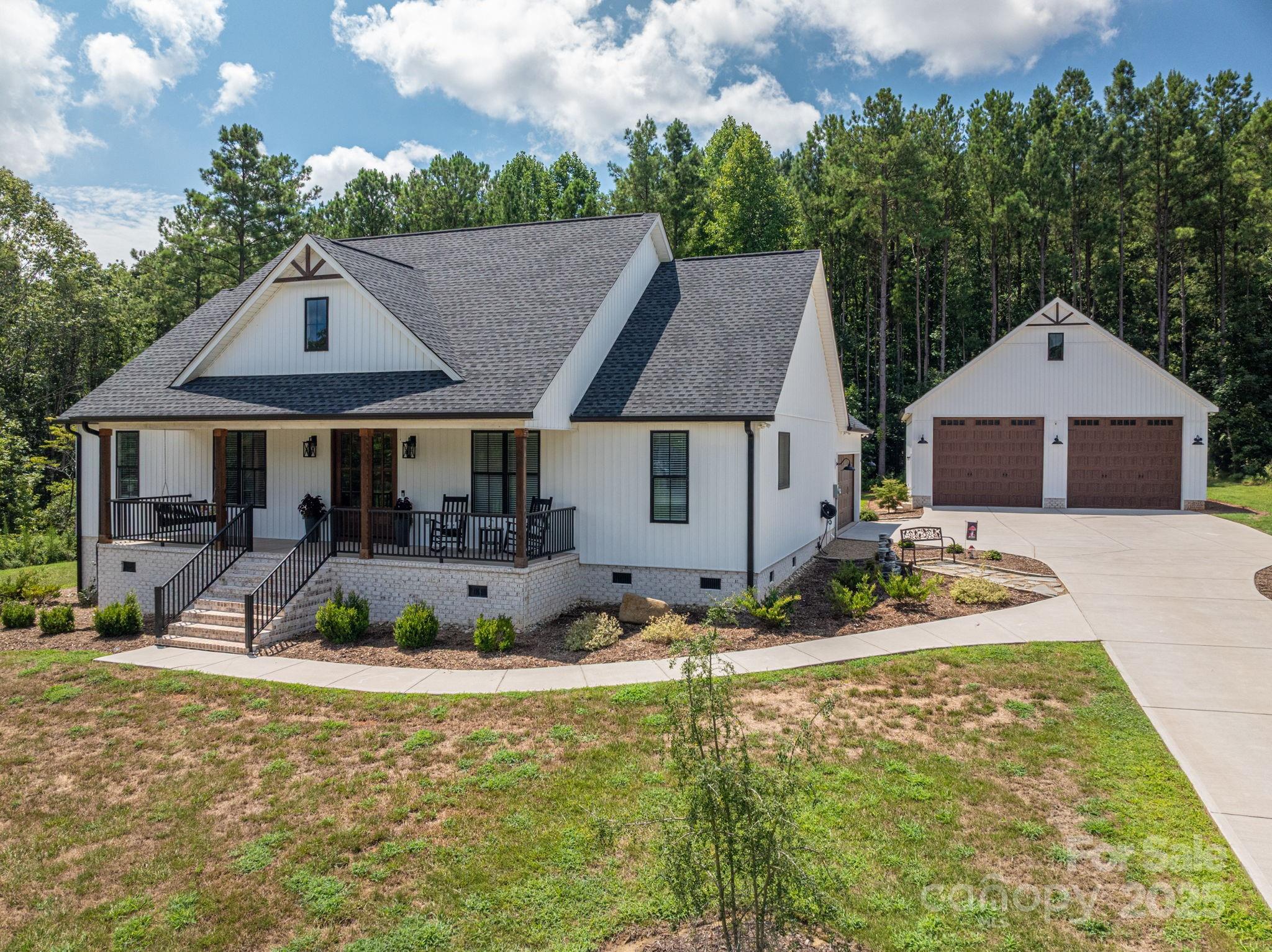 Tucked in Clover’s coveted Magnolia neighborhood, this fully custom 2022-built modern farmhouse is where craftsmanship meets comfort. From the moment you arrive, you're greeted by soaring stained ceiling beams, elegant built-ins, and trim work that whispers luxury in every detail. The chef’s kitchen features quartz countertops, custom cabinets, and open shelving—just steps from the walk-in pantry and massive primary closet with direct laundry access. Enjoy your mornings on the oversized screened porch and evenings by the fire pit. The attached 2-car garage is complemented by a 36x36 detached garage with 14’x12’ doors and 200amp service—perfect for your RV or boat. Gas HVAC, Rain Bird irrigation, and thoughtful design throughout, including a shared bath for secondary bedrooms, complete this quiet Magnolia retreat. Located minutes from both downtown Clover and York, you’ll have easy access to numerous local amenities.