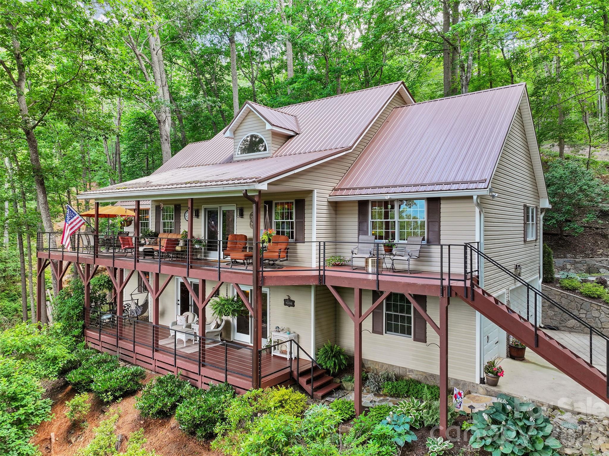Discover this exquisite traditional custom home nestled in the prestigious gated community of Springdale Country Club. Offering approximately 2,900 square feet of thoughtfully designed living space, this residence seamlessly blends timeless elegance with modern comforts, all while embracing the stunning natural beauty of Western North Carolina’s mountain landscape. The main level welcomes you with an impressive open floor plan anchored by soaring 17-foot cathedral ceilings that create a bright, airy atmosphere. A striking dual-sided gas log fireplace serves as the heart of the home, offering warmth and ambiance to both the living and dining areas. The dining space flows effortlessly into a very spacious kitchen featuring premium Thermador appliances, including a five-burner cooktop and a brand-new double oven. A large center island with elegant granite countertops provides ample workspace and casual seating at the breakfast bar—ideal for family gatherings or entertaining. Just off the main living area, a cozy den offers flexible space that can easily serve as a formal dining room or additional living area. The primary suite is a true retreat on the main level, highlighted by a beautiful vaulted ceiling and its own dual-sided gas log fireplace. The luxurious primary bath includes a spacious walk-in shower with custom faucets and controls, along with a generous walk-in closet. Convenient main-level laundry completes the thoughtful layout. Upstairs, an open loft with captivating views overlooks the main living area and provides versatile space for a home office, reading nook, or additional gathering spot. A secondary bedroom and full bath offer comfort for family or guests, while unfinished storage above the garage provides practical expansion potential. The finished basement expands the living options with a large family room centered around a gas log fireplace, perfect for movie nights or casual entertaining. A guest en suite with walk-in closet ensures privacy and convenience, complemented by a dedicated exercise room, abundant storage, and the attached double-car garage. Outside, the home shines with its covered double decks overlooking breathtaking mountain range views. The rear covered deck is an entertainer’s dream—ideally suited for grilling, al fresco dining, and private relaxation amid the serene surroundings. Residents of Springdale Country Club enjoy optional access to exceptional amenities, including golf, a clubhouse restaurant, massage services, and much more. This custom home offers the perfect balance of luxury, functionality, and mountain lifestyle in one of the area’s most desirable gated communities. Ideal for those seeking a refined retreat with room to grow, this property is ready to welcome its next owner. Contact us today for a private showing and experience the exceptional lifestyle that awaits at Springdale Country Club.