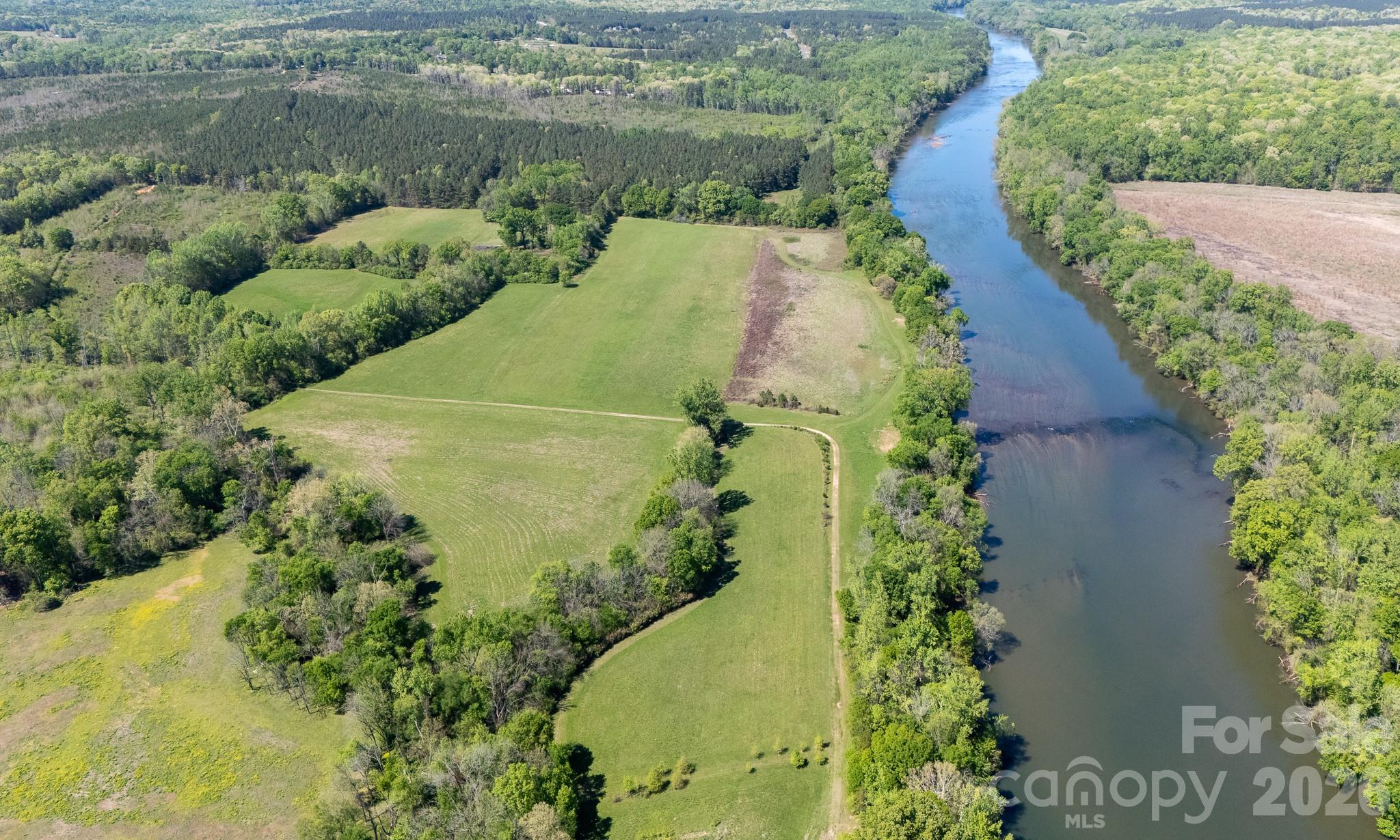 Owning this 82.5 acres on the Catawba River means having over 2,200 feet of your own private waterfront and the kind of quiet that is getting harder to find. Tucked behind a gated private road, this land is mostly cleared and ready for whatever you have in mind. It is spread across four parcels, so there is plenty of room to breathe, whether you are looking to start a farm, build a family compound, or design a premier horse farm and equestrian estate. With significant acreage already cleared, the transition to lush fenced pastures and hay fields is seamless, providing ample space for a custom barn, training arenas, and miles of private riding trails. The river’s edge creates a vibrant corridor for local wildlife and biodiversity, making it an ideal setting for hunting, trail riding, or simply enjoying the natural ecosystem. Because it is zoned for Rural Development, the peaceful, agricultural character of the area is protected, giving you the freedom to enjoy the land without the worry of rapid growth moving in next door. This is a rare chance to own a significant, wide-open slice of York County with direct river access and total privacy. To respect the privacy and security of this estate, all tours must be accompanied by a licensed agent and require a gate code for entry.