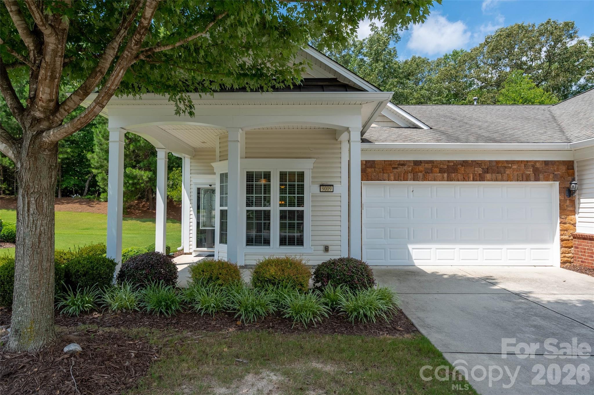 Welcome home to this beautifully maintained end-unit Kenwood Villa, gleaming w/ natural light, nestled against a wooded backdrop in highly sought-after Sun City Carolina Lakes! This move-in ready home boasts granite countertops & sleek black appliances. Enjoy casual meals in the sunlit breakfast nook or more formal dining in the dining area. Spacious living room, w/hardwood floors & abundant natural light. Primary bdrm features walk-in closet & en-suite bath. Generously sized guest bedroom could also serve as an office/hobby room. Step into the sunroom to unwind while enjoying views of the private, tree-lined backyard—a serene retreat surrounded by mature landscaping complete w/ large green common space next to unit for extra privacy. 

Completely immaculate & 100% move in ready! Active lifestyle community: 2 outdoor pools, indoor pool, 3 hot tubs, 15 lakes, trails, pickle ball, gazebos, social events galore & more! Come live your best live at Sun City Carolina Lakes!