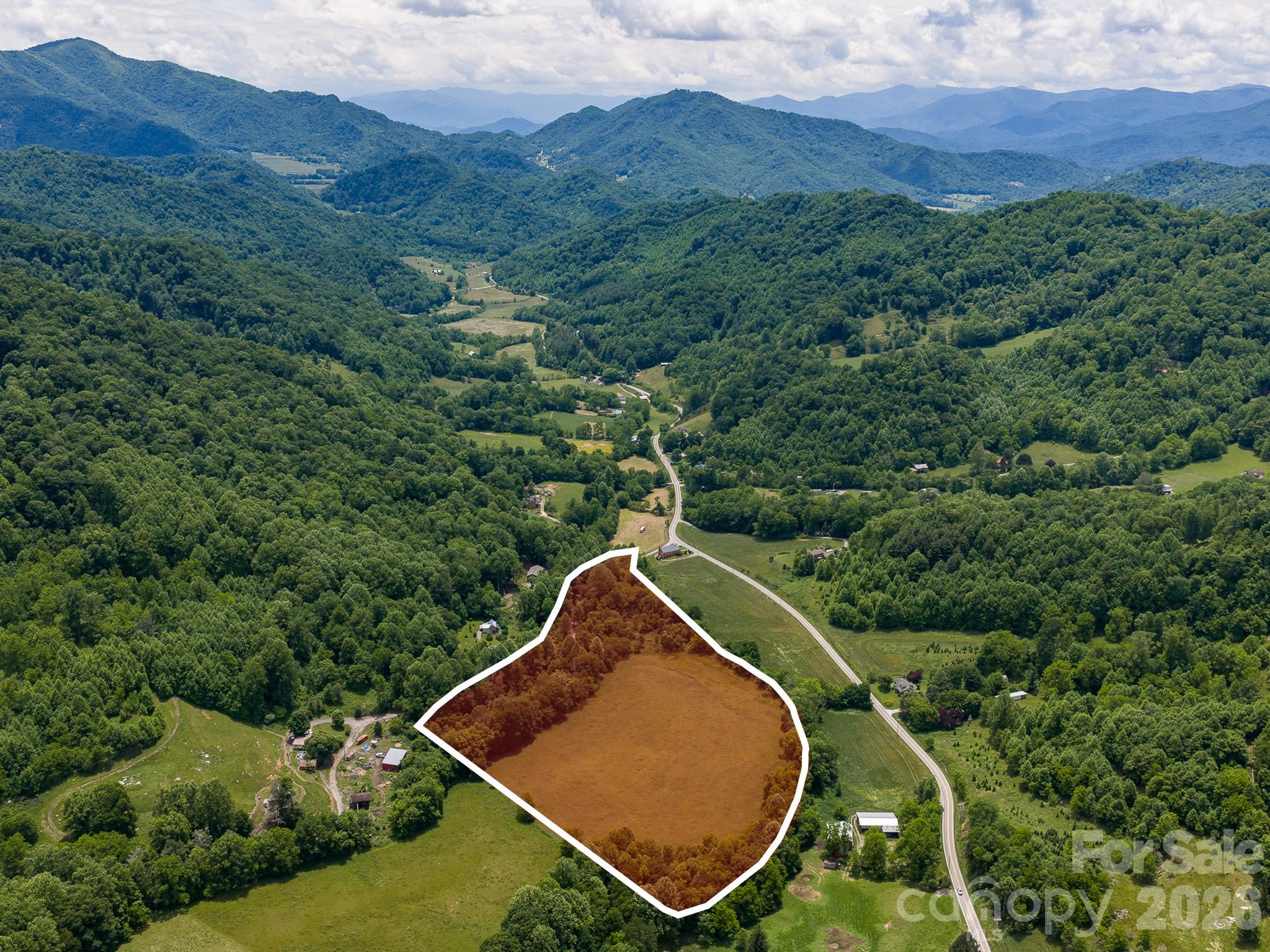Tucked away in the peaceful Fines Creek community, this stunning 14.5-acre tract offers the kind of quiet beauty that’s getting harder to find. Gently rolling & unrestricted, the land has been lovingly used for hay production, w/ approximately 8 acres of open pasture complemented by wooded acreage for privacy & shade. A picturesque stream winds through the property, while mountain views create a soothing backdrop in every season. Located just off a state-maintained paved road, enjoy easy access while still feeling worlds away. Outdoor adventure awaits just minutes away at Max Patch Bald, w/ downtown Waynesville only 20 minutes & Asheville about 45 minutes from your doorstep. Whether you envision a private estate, working farm, or charming mini-farm, the land lays beautifully and offers endless possibilities. It’s rare to find usable, unrestricted farmland this inviting—an ideal place to slow down, spread out, and enjoy the mountain lifestyle.