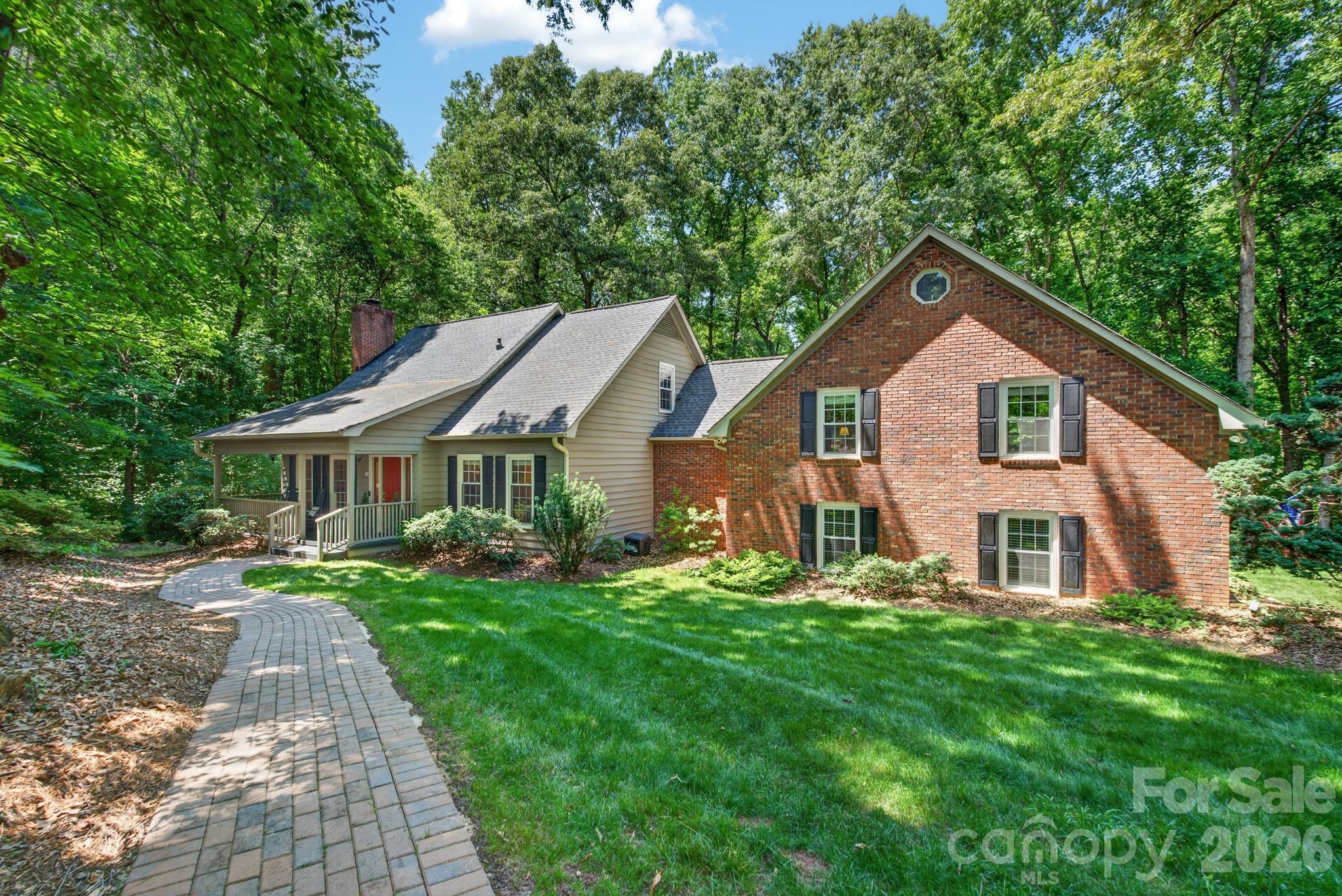 Nestled on more than 2½ private acres in sought-after Olde Williamsburg Village, this beautifully maintained single-family home offers a rare blend of natural beauty, warmth, and comfortable living. From the moment you enter the welcoming foyer, you’ll appreciate the inviting atmosphere and thoughtful design. Rich hardwood flooring throughout most of the main level adds timeless character and warmth. At the heart of the home is the beautifully remodeled kitchen, designed for both everyday living and entertaining. Open to the dining area, it features a stunning granite island perfect for gatherings with family and friends. An authentic old-brick wall with distinct architectural details showcases the built-in microwave, oven, and five-burner gas cooktop, creating a distinctive focal point. Abundant storage abounds with three pantries, a blind-corner swing-out organizer, and a cleverly concealed pull-out TV cabinet. French doors lead to a secluded screened porch, an ideal spot to relax while enjoying peaceful views and the sounds of nature. A spacious Trex deck provides additional outdoor entertaining space, while a second upper deck offers access from the recreation room. Above the spacious two car garage, an expansive recreation room features beautiful tongue-and-groove cathedral ceilings, a loft, full bath, and office nook, all ideal for guests, a home office, recreation room or multi-generational living.The primary suite on the main level includes an adjoining dressing/vanity area and a generous walk-in closet. Upstairs, two additional bedrooms share a full bath and a large linen/flex space. All three bathrooms have been tastefully updated.  The home's exterior is cedar siding and brick.  Also the property’s mature, low-maintenance landscaping enhances both beauty and privacy. Additional recent upgrades include crawl space encapsulation, new brick walkway, Trex flooring on front porch and rear deck and a new HVAC system (2026).  Experience peaceful, private living with unique architectural character and modern updates — all within the charm of Olde Williamsburg Village and the top-ranked school district in the state.
