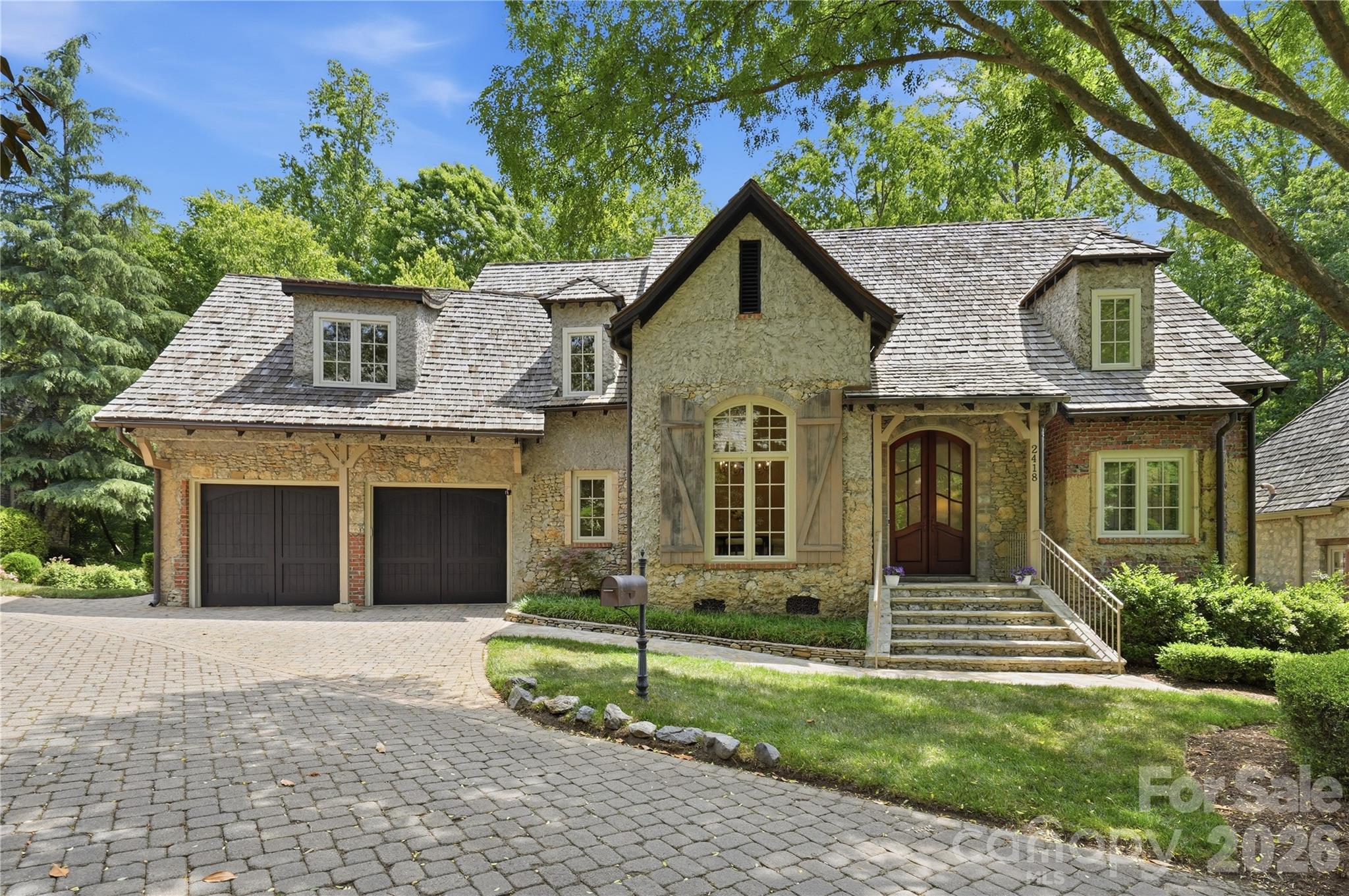 Experience the charm and elegance of the French countryside in Courance, an extraordinary enclave within the prestigious estates of Pellyn Wood. Tucked away in the heart of highly sought-after South Charlotte, this enchanting gated neighborhood is unlike anything else in the area, with timeless stone architecture, cobblestone streets, glowing gas lanterns, and beautifully landscaped green spaces that evoke the feeling of a private European village—all just minutes from SouthPark and Strawberry Hill.

This truly special residence offers a rare combination of character, comfort, and thoughtful updates. With a fantastic floor plan designed for both everyday living and entertaining, the home features refinished hardwood floors, new carpet and paint, and tasteful upgrades throughout. Expansive windows across the main living areas frame picturesque views of the lush outdoor spaces and invite natural light throughout the home.

The elegant dining room makes a striking first impression with a vaulted ceiling, a dramatic chandelier, and oversized windows. The kitchen is both functional and refined, anchored by a Wolf range, built-in refrigerator, and custom cabinetry, while the charming breakfast area feels as though it belongs in a European countryside retreat. The main-level primary suite is a peaceful sanctuary, offering beautiful views of the serene patio and green space beyond.

Upstairs, the home continues to impress with two additional bedrooms, a spacious bonus room or optional fourth bedroom, and a versatile office/flex space ideal for working from home, hobbies, or a private retreat. Recent improvements include new carpet and fresh paint throughout much of the upper level, along with two generously sized bathrooms that provide both comfort and functionality.

Outdoor living is equally captivating, with a stunning patio and secluded setting that create an ideal backdrop for relaxing or entertaining. Surrounded by mature trees and professionally maintained landscaping, the home offers exceptional privacy with the convenience of low-maintenance living.

Perfect for buyers seeking the ease of a lock-and-leave lifestyle without sacrificing the privacy and feel of a single-family home, this one-of-a-kind property combines timeless architecture, an unbeatable South Charlotte location, and the rare opportunity to live in one of the area’s most distinctive communities.