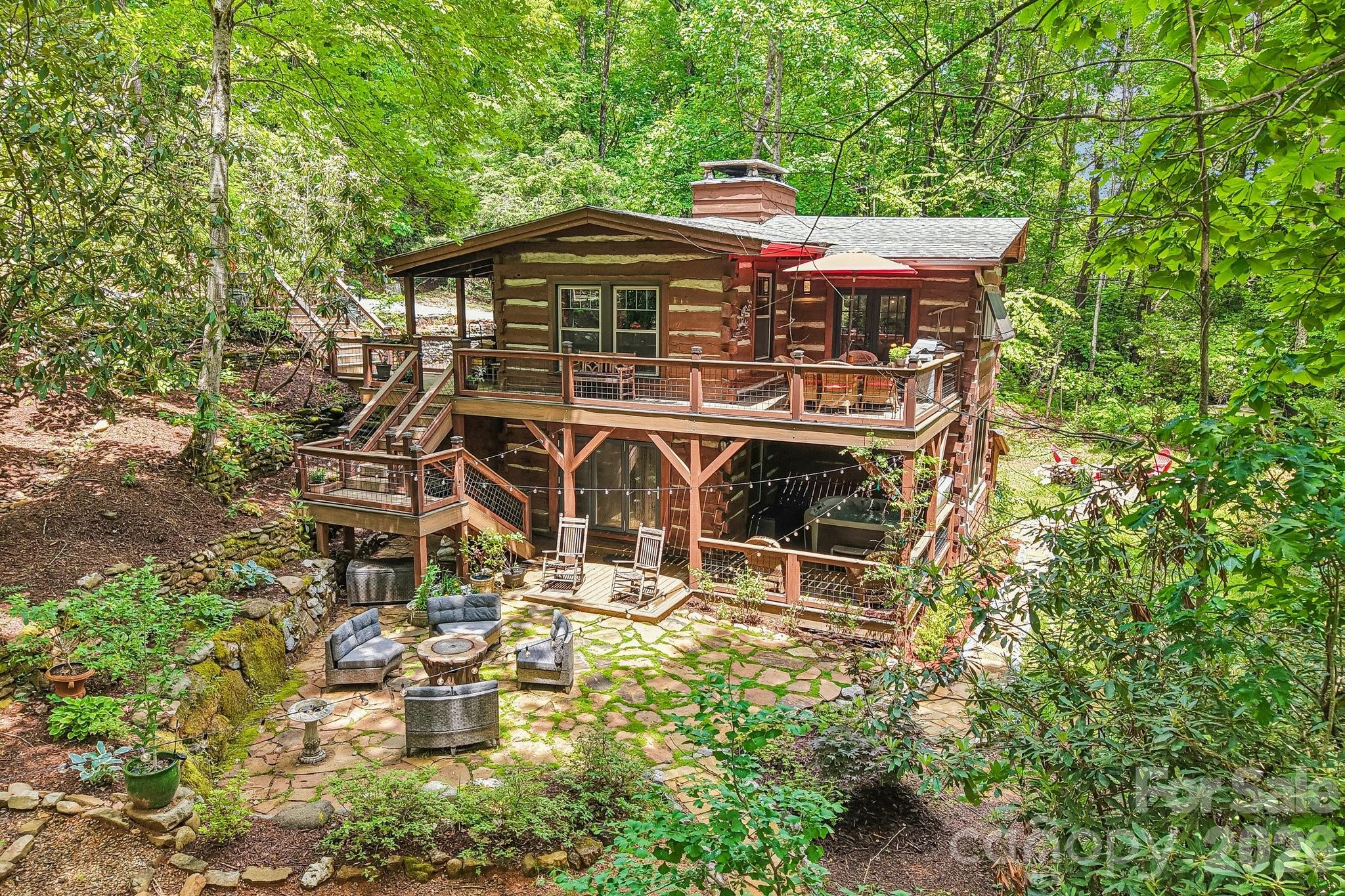 Quintessential mountain cabin in Lake Toxaway, ideally located near Sapphire, Cashiers, hiking, biking, shopping, dining, and the many outdoor adventures of Western North Carolina. Nestled in an enchanting, ultra-private setting, this 3-bedroom, 3-bath retreat is filled with warmth, character, and timeless mountain charm. Thoughtfully updated, the home features beautifully renovated kitchens and baths that blend modern comfort with the authentic feel of a classic mountain getaway. Expansive decks, patios, and winding walking paths invite you to relax and reconnect with nature, while the soothing sound of the waterfall creates a peaceful backdrop for everyday living. Whether you’re looking for a full-time residence, weekend escape, or investment opportunity, this storybook cabin offers the perfect blend of privacy, charm, and mountain lifestyle.