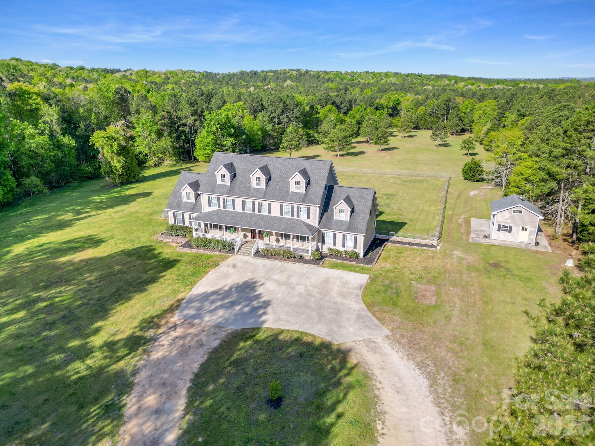 *Seller is Motivated* Rare opportunity to own approximately 45 acres, and can be subdivided! Acreage like this is becoming increasingly difficult to find. The spacious farmhouse offers over 5,400 square feet with multiple living areas, generous bedrooms, and true hardwood flooring. While some cosmetic updates may be desired, the value of this property lies not only in the home, but in the incredible 45 acres that surround it. Whether you're looking for a private estate, family compound, mini farm, recreational retreat, or investment opportunity, this property offers endless possibilities. Home was custom built and original owners. Hardwood flooring throughout most of the main and upper levels, spacious living areas, and a large kitchen designed for entertaining with an oversized island, gas cooktop, ample cabinetry, and generous dining space, formal dining room and living room are both conveniently located off the kitchen.  Main floor has two primary bedrooms with new LVP flooring, offering flexibility for multi-generational living or guest accommodations. Head upstairs to a large open loft, three additional bedrooms, office, and two full bathrooms. The third floor offers a large bonus room perfect for a media room, playroom, gym, or additional flex space.  The property includes, an expansive updated deck, fenced area perfect for pets, and three outbuildings, one featuring a lean-to—ideal for equipment storage or future agricultural use. Enjoy peaceful country living while remaining conveniently located to Lancaster, Rock Hill, and Charlotte. Properties offering this combination of acreage, privacy, square footage, and endless possibilities are becoming increasingly difficult to find. Seller is highly motivated and has aggressively repositioned the property for a quick sale.