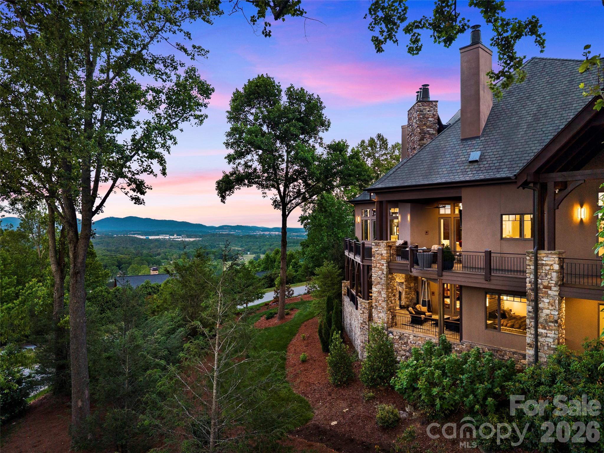 Stunning views! 
Perched within the private gated community of The Cliffs at Walnut Cove, 47 Ridge Pine Trail is an extraordinary mountain modern estate where breathtaking Blue Ridge views become the defining design element. Thoughtfully curated to frame the ever-changing beauty of the mountains from nearly every major room, this residence pairs architectural drama with refined livability on an exceptional scale.

A soaring two-story vaulted great room sets the tone, anchored by walnut hardwood floors, a striking spiral crystal chandelier, and walls of glass that open to more than 2,000 square feet of outdoor living and entertaining space across two levels. Covered and open-air gathering areas, multiple lounge settings, fireplaces, and an outdoor kitchen create a seamless connection to the surrounding landscape.

The chef’s kitchen is both sophisticated and inviting, appointed with Viking professional appliances, an impressive marble prep island, copper-accented marble breakfast bar, farmhouse sink, prep sink with reverse osmosis filtration, and a walk-in pantry. The formal dining room offers an elegant setting for entertaining, while the private primary suite is a true retreat with its own wing, fireside sitting area, bespoke dressing room, and spa-inspired bath featuring a soaking tub, expansive shower, dual vanities, and a picture window framing the mountains like living art.

The terrace level was designed for exceptional leisure and hospitality, offering a dramatic entertaining area with pool table, theater room, full bar, fitness room, and a hidden wine cellar reminiscent of a private Tuscan tasting room. Three ensuite guest suites open to the lower terrace, while a separate guest or staff suite above the garage provides added privacy and flexibility.

Additional highlights include a private elevator, Lutron Caseta lighting system, Rinnai tankless water heater, mudroom, spacious laundry room, and finished 3-car garage. Just minutes from South Asheville, this remarkable home also offers the opportunity to qualify for membership at The Cliffs, with access to golf, dining, wellness, and an exceptional collection of mountain and lake club amenities.

The seller is offering a home warranty to be purchased or transferred to the buyer.