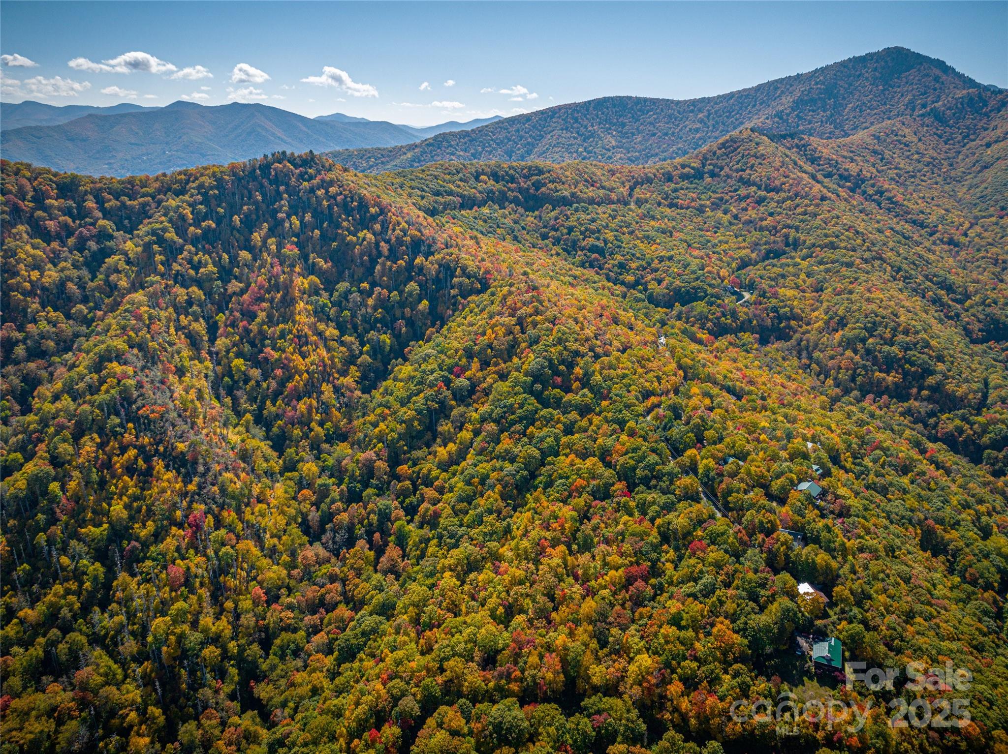 Big Sunset Views, roughed in driveway, and city water on 2.1 acres with the potential for a small home or two homes. The views from these two adjoining lots - look down into Maggie Valley and across the ranges towards the Great Smoky Mountains.  Lightly restricted property allows for one or two homes on these two lots. The houses may be small or large... Roads are paved most of the way up to the lots but the last few yards are gavel. Driveway is rough gravel with the bigger base stone installed. The driveway could be designed to access both lots.. This area is close to the Maggie Sanitary conservation land and has beautiful hiking on the roads and up to the ridgetop, The neighborhood is high elevation with cool summer temperatures and a special peacefulness found only at the higher elevations. This is a beautiful area to build a second home with big windows to take in the views.