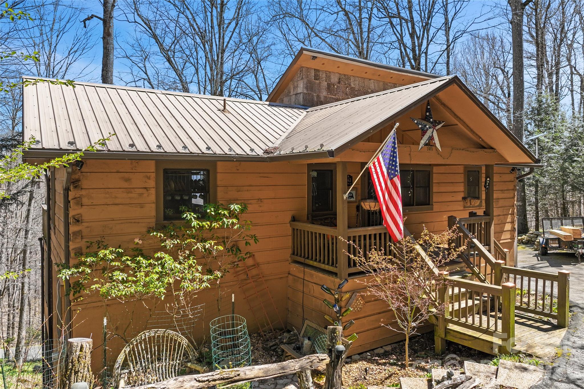 Nestled in the coveted Wolf Laurel community, this stunning mountain cabin is a true sanctuary. From the moment you step onto the inviting covered porch, you’ll feel at home in this warm, rustic retreat. The great room, with its soaring vaulted ceilings, towering stone fireplace, and expansive windows, bathes the home in natural light, while the open area above offers a cozy escape for reading or relaxing. The gourmet kitchen dazzles with bold blue cabinetry, butcher block countertops, and stainless steel appliances perfect for preparing family meals or entertaining guests. The spa-inspired primary bathroom with heated floors is a luxurious retreat, with natural stone accents, a walk-in shower, and dual sinks. A large foyer space perfect for a home office or reading nook, open kitchen dining area with french doors opening to a private deck showcasing breathtaking mountain vistas. Down stairs features living room, game/media room both with french doors to the lower deck, two addition bedrooms and a full bath. Every detail, from the warm wood beams to the handcrafted accents, embodies rustic charm with modern comfort. Just minutes from Hatley Pointe Ski Resort and all the amenities of Asheville, this home is a rare find a perfect balance of adventure, tranquility, and luxury living.