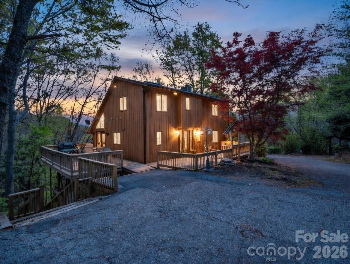 Tucked inside the gates of Rumbling Bald on Lake Lure, this inviting mountain retreat offers space, comfort, and a peaceful natural setting on .87 acres. Surrounded by mountain views, the property creates a true sense of escape while still being close to everything. Designed for both relaxation and gathering, the home features 4 bedrooms and 2.5 baths, including a main-level bedroom and full bath for added convenience. Each level offers its own space to unwind, from the cozy living room with a stone fireplace to the lower-level den and game room. Perfect for a game of pool, movie nights, or hosting guests. Updated decks provide multiple outdoor living areas in the serene natural setting. One deck area has easy access from the kitchen, ideal for morning coffee or evenings spent taking in the mountain air. After a day of exploring, unwind in the private sauna inside the home or retreat to the lower-level bonus space with a separate entrance. This bonus area is perfect for a workshop, art studio, or relaxed bar/lounge. Located just minutes from outdoor adventures like Chimney Rock State Park, hiking, rafting, and horseback riding, this home also includes access to Rumbling Bald’s sought-after amenities, including a private beach, wellness center, multiple pools, restaurants, cabana, and two championship golf courses. This mountain getaway was operating as a successful short-term rental and is offered fully furnished, including the pool table, making it a turnkey opportunity in one of Lake Lure’s most desirable gated communities. Both sliding doors have just been updated and some decks are newly updated. More than one photo has been virtually staged.