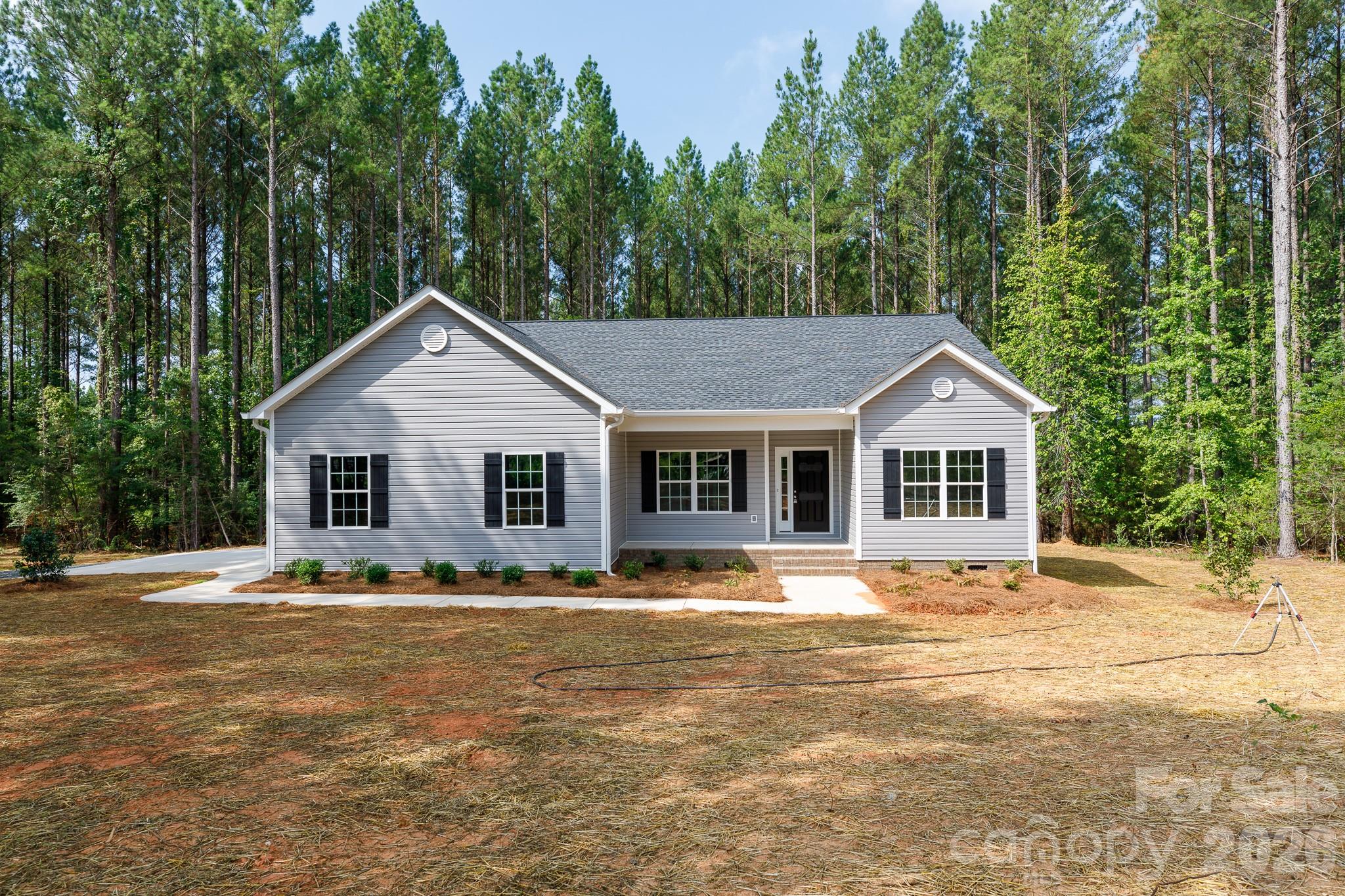 Welcome home to this beautifully designed custom ranch offering the perfect blend of modern style, thoughtful design, and peaceful privacy. Nestled on a spacious wooded lot, this 3-bedroom, 2.5-bath home features an open-concept floor plan with soaring vaulted ceilings, abundant natural light, and quality finishes throughout.

The heart of the home is the stunning kitchen, complete with white shaker cabinetry, granite countertops, a large center island with seating, stainless steel appliances, pantry, and an open flow into the dining area and expansive great room—perfect for entertaining or everyday living.

The spacious owner’s suite is privately located away from the secondary bedrooms and includes a luxurious en-suite bath with dual vanities, a walk-in tiled shower, linen storage, and a generous walk-in closet with easy access to the laundry room for added convenience.

On the opposite side of the home, two additional bedrooms share a full bath, creating an ideal layout for family or guests. A convenient powder room is located just off the garage entrance and away from the main living area.

Step outside to enjoy the large screened-in covered porch overlooking the private backyard—an ideal space for morning coffee, outdoor dining, or relaxing while enjoying the peaceful wooded surroundings. The lot features an existing cement pad that is ideal for parking equipment, campers or placing a storage shed.