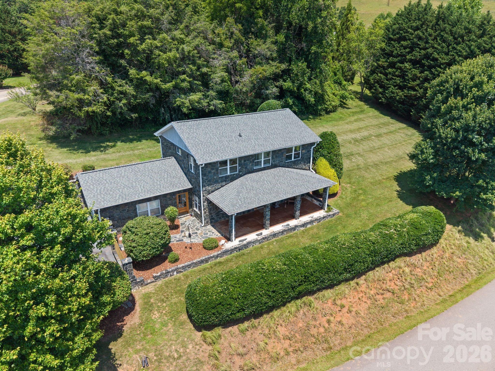 I am excited to share a unique new listing located in the Mountain Home Estates subdivision. This meticulously maintained, one-owner home features a striking black granite rock exterior and a thoughtful design that perfectly balances country living with close proximity to town.

The interior boasts nine-foot ceilings, elegant crown and floor molding, and large windows that fill the space with natural light. The kitchen is highlighted by granite countertops, oversized maple cabinets, and flows into the dining area. The living room is located across from the kitchen and features a beautiful black granite hearth for the gas logs, and a full bath. A wall of cabinets in the hallway makes execellent storage. 

The primary bedroom is filled with natural light, accomodates a king bed, has a walk in closet and enjoys an ensuite bath with a walk in shower, and soaker tub. The second and third bedrooms both have double closets and large windows. The 3rd bathroom features a shower tub combo, and a bidet. The laundry closet is located in the hall with shelves for storage.

Practicality was a priority in this home's design, which includes a chairlift, handicapped bars in the bathroom, a dedicated closet under the stairs for storage, a closet in the living room for the well pump and water filter, as well as an organized garage closet housing the HVAC unit. Outside, you can enjoy the surrounding nature from the large covered patio, which is ideal for bird watching and entertaining.

This property offers an ideal location for those seeking a quiet setting without sacrificing convenience. The home is situated just 5 minutes from downtown Mars Hill, providing easy access to a grocery store, a farm stand, local coffee shop, restaurants, the post office, and Mars Hill University. Additionally, Weaverville is a short 15 minute drive away, and downtown Asheville can be reached in approximately 30 minutes.

This home is truly a must-see to appreciate the quality of its maintenance and design. Please let me know if you would like to schedule a tour or if you have any questions regarding the property.