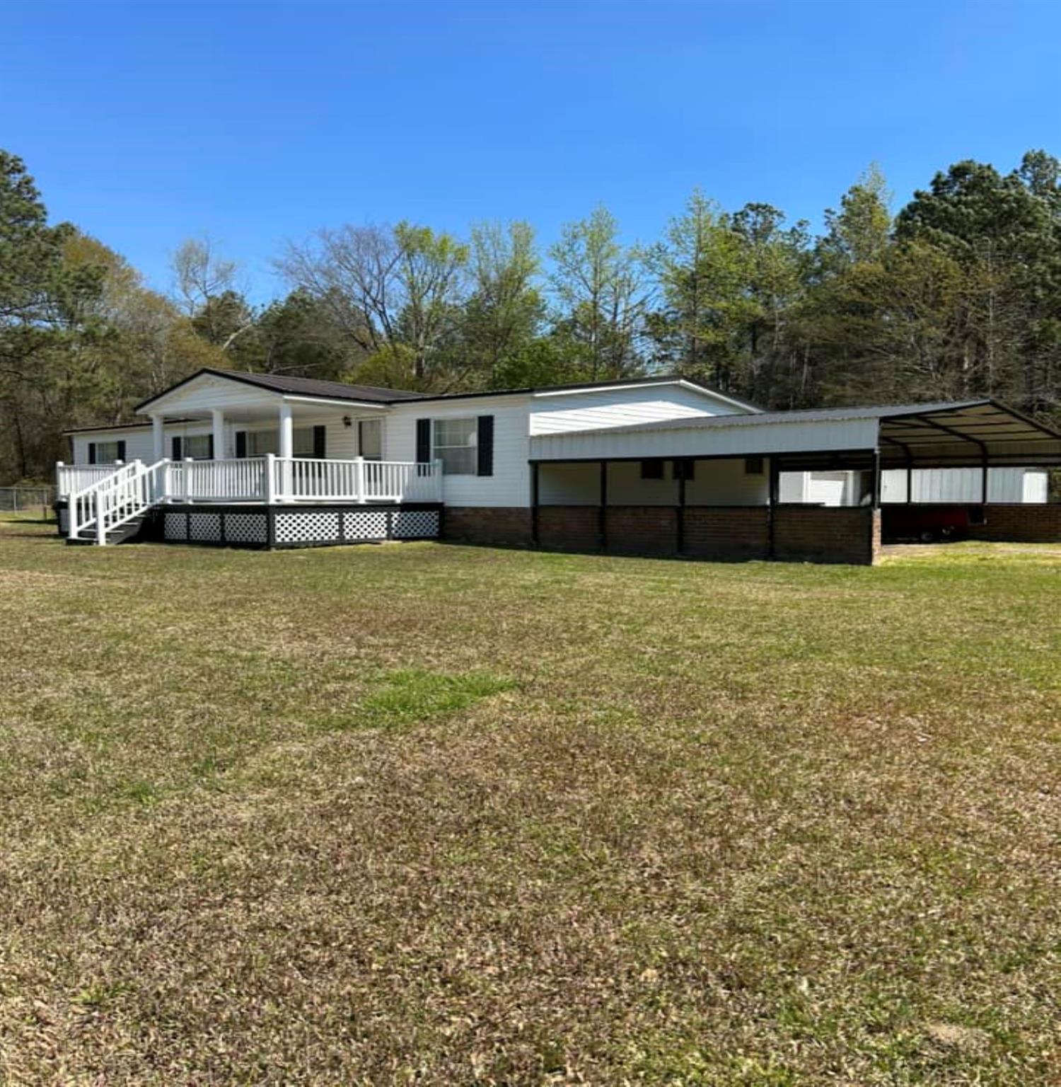 Turn-key ready! Save time and just pack your bags! The furniture and appliances will convey. This large, private lot and well-maintained home is all that you need! Relax on the spacious, covered, front porch and swing while overlooking the sunset across the beautiful lawn or have dinner on the private, covered back porch. The convenience of city water is available. There is plenty of natural lighting throughout the home. The primary bedroom features a grand ensuite and newly renovated bathroom with two vanities and a walk-in shower. There is another full guest bathroom and two more spacious bedrooms. The fireplace is perfect for relaxing or step outside to work in the private shop that has a roll-up door, electricity, access to be heated/cooled, excellent storage, shelving and a work bench. This is a handy person's dream! Building could also be a potential family/in-law suite. There are two additional shops for storage. Perfect for entertaining with a concrete patio and fenced in yard.