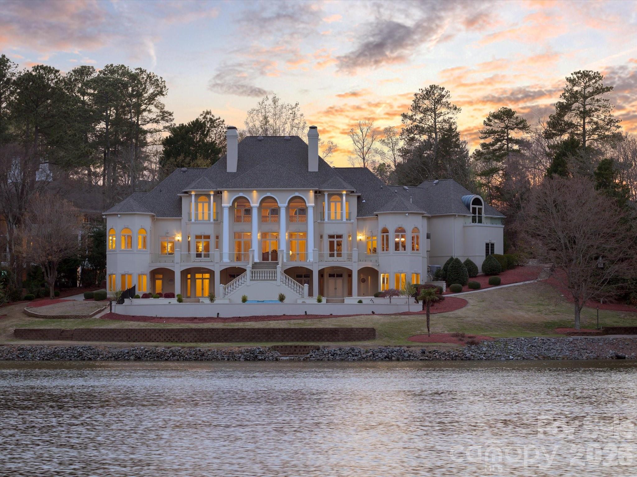 A Charlotte Palace of Unrivaled Luxury on Piper Glen Lake!
 Discover a truly one-of-a-kind waterfront estate nestled in the heart of Charlotte, overlooking the serene lake at Piper Glen Country Club. This stately residence presents a unique opportunity for today's discerning buyer, offering meticulous finishes and detailing rarely found.
 The inspiring, grand entrance immediately captivates with panoramic lake views from this notable property. Step inside to soaring ceilings, exquisite marble floors, and custom designer lighting. The main living spaces open seamlessly to a sprawling rear terrace, inviting the beauty of the outdoors in.
 The gourmet kitchen is a chef's dream, appointed with Wolf and Subzero appliances, a center island, and breakfast bar and a sunny breakfast room—the perfect setting to start your day. Adjacent is a cozy keeping room with a fireplace, while the elegant formal dining room and butler's pantry are ideal for sophisticated entertaining.
 The spectacular Primary Suite is a true sanctuary, featuring a fireplace, expansive sunrise views, and two private baths complete with a morning bar, steam shower, bidet, and custom dressing areas.
 The upper level is home to three spacious ensuite bedrooms, each with a balcony overlooking the lake, built-in desks, and expansive walk-in closets. This floor also includes a flexible room perfect for an office and an expansive bonus room with a built-in wet bar, balconies, and convenient laundry facilities.
  The lower level is dedicated to amazing recreational amenities, including a home theater with stadium seating, a fully outfitted bar, and versatile space ready for billiards, poker, and home gym. It also features a private office and a pool bath with a changing area, which opens to an expansive summer porch overlooking the pool and spa. The shoreline offers a tranquil terrace with a tree canopy and a dedicated fishing spot. Additional practical luxuries include an elevator servicing all three levels and an additional lower-level garage with workshop space and Private Guest Retreat!  Presenting in pristine condition and ready for immediate occupancy, this distinguished estate is truly one of Charlotte's finest. Welcome to the ultimate in vacation living, every day. Perfection awaits in Piper Glen—Welcome Home.