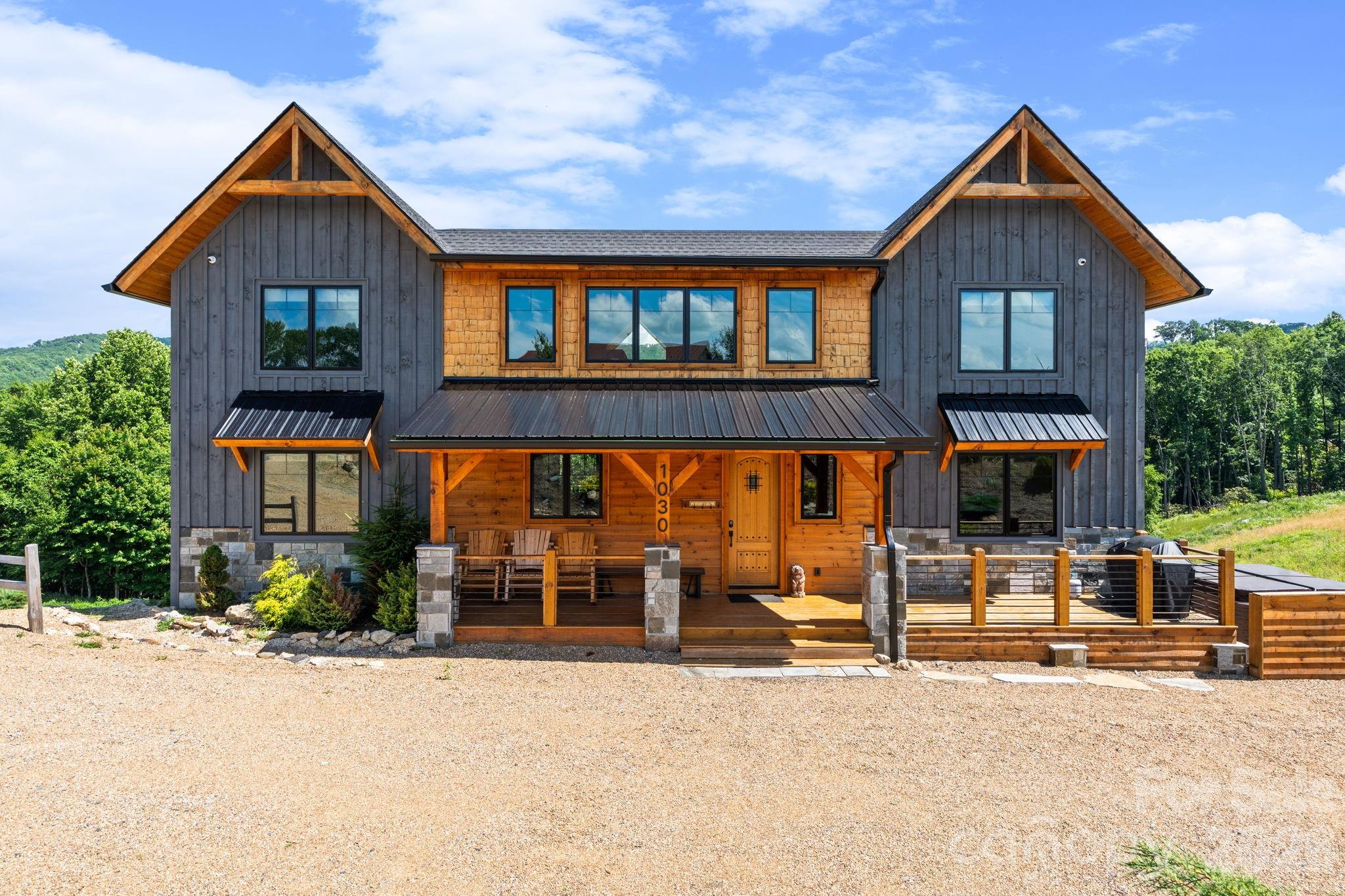 Welcome to Mountain Time Lodge, a luxurious mountain retreat located in the highly sought-after Lodges at Eagles Nest. Nestled within The Farms at Eagles Nest, this exceptional property sits on nearly six acres in a quiet section of the community and offers beautiful long-range mountain views, with the rear of the home facing south to capture both sunrise and sunset exposures. Designed to accommodate large families and groups with ease, the home features six spacious en-suite bedrooms, including two king suites on the main level. The stunning primary suite offers a spa-like bathroom with a soaking tub and beautifully tiled shower. At the heart of the home is a large chef’s kitchen appointed with beautiful Café appliances, granite countertops, a generous island, and designer finishes throughout. The open-concept great room seamlessly connects the kitchen, dining area, and inviting living space, creating an ideal setting for gathering and entertaining. Upstairs, two separate wings provide additional privacy with well-appointed guest suites, while the loft offers a comfortable recreation and gathering space with a TV, pool table, and foosball. Outdoor living is equally impressive, with an expanded deck, fireplace, rocking chair porch, fire pit area, and hot tub—all positioned to enjoy the surrounding mountain scenery and peaceful natural setting. Recent updates include a new roof and gas water heater, both installed in 2023, offering added peace of mind. Additional features include a generator, ample parking, and a nearly six-acre homesite offering excellent privacy. Sold fully furnished and ready to enjoy, Mountain Time Lodge is conveniently located just minutes from Eagles Nest amenities including the North Pavilion, Fitness Lodge, Sportsman’s Lodge, and Eagles Nest Winery, as well as area ski slopes, hiking and biking trails, and premier golf courses. This property truly captures the best of Blue Ridge Mountain living.