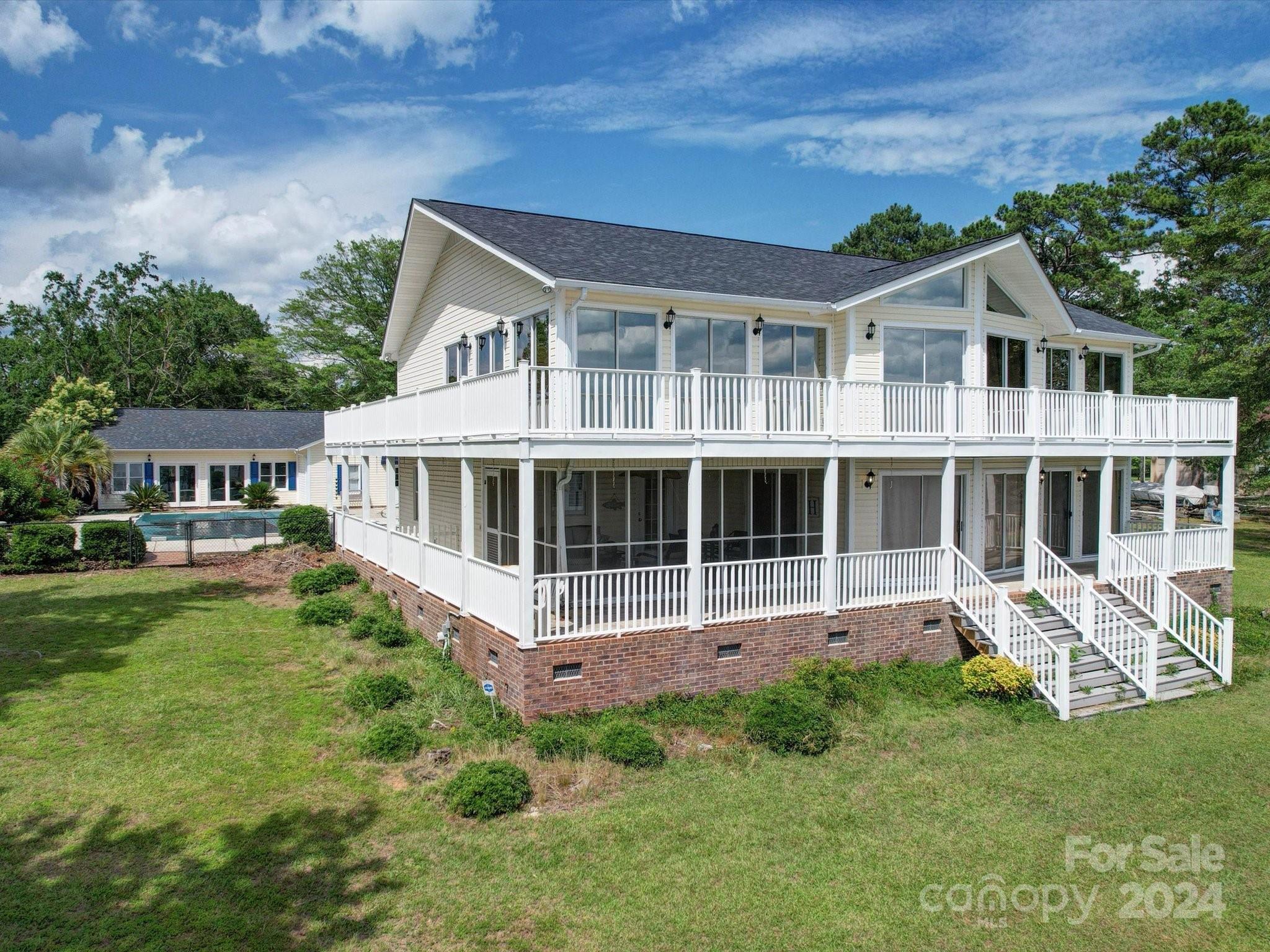 Get your Vitamin D and H2O here at Lake Wateree & in ground pool! Gorgeous main channel home offers 4114 SF with upper/lower kitchens, upper/lower great rooms and upper/lower wrap around decking. Entertain family & friends pool side or on game day in detached 600 SF pool house with full kitchen, (2) 1/2 baths and rear screened porch. Covered kennel. Park the autos in detached 4 bay garage and dock the water toys on private pier with 2 boat lifts and 2 boat slips on 158' of shoreline. Enjoy lake life and all the perks! Offered in present condition.NOTE: Home is NOT in a flood zone!
