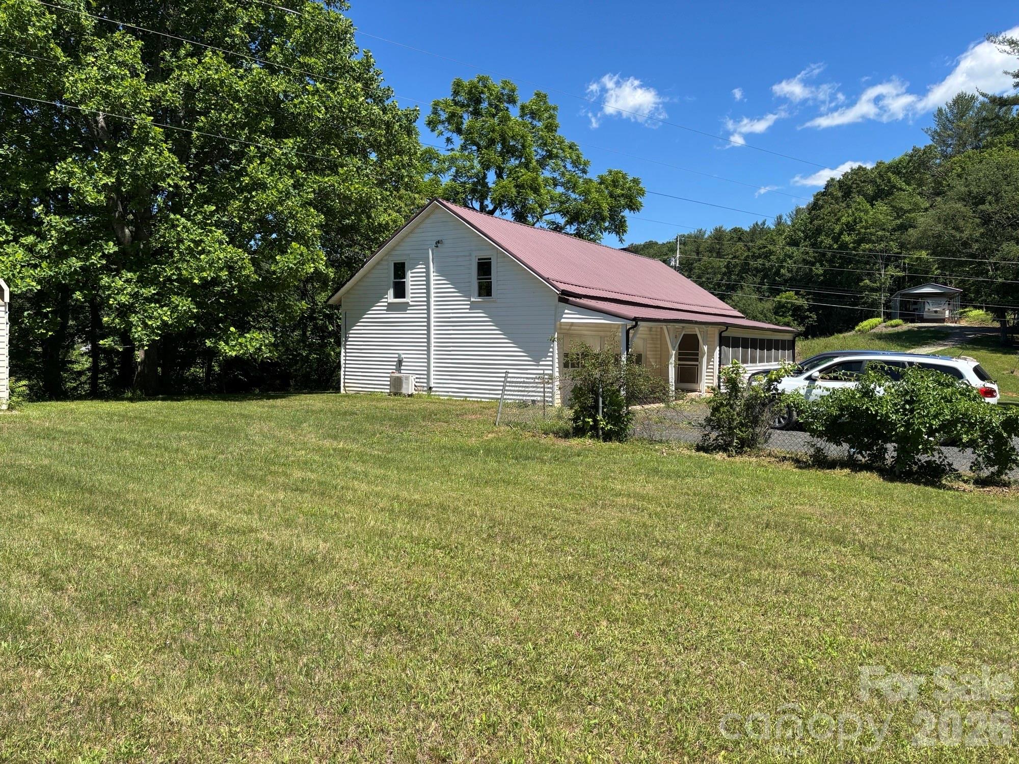 This home has had many updates. You can move right in and just add your own personal touches. New cabinets and counter tops for the kitchen and a new refrigerator. There is a new bathroom upstairs with a washer and dryer but there is also a laundry room off the kitchen downstairs. New windows have been installed. The metal roof has new lifetime screws and new flashing. New guttering has been installed.  The hot water heater was replaced in 2024. 
This spacious home has lots to offer and has lots of storage space Nice screened front porch for your sitting pleasure as you enjoy the fresh mountain air and the sounds of nature. There are 2 outbuilding on the property and believe it or not the yard is flat. Come have a look. New grape vines will soon produce plenty of fruit for jelly and juice, and plenty of space for a garden. Easy access to Bakersville and only a short drive to Spruce Pine and Johnson City. And don't forget to visit beautiful Roan Mountain several times a year. Make this home yours today, call for a showing appointment.